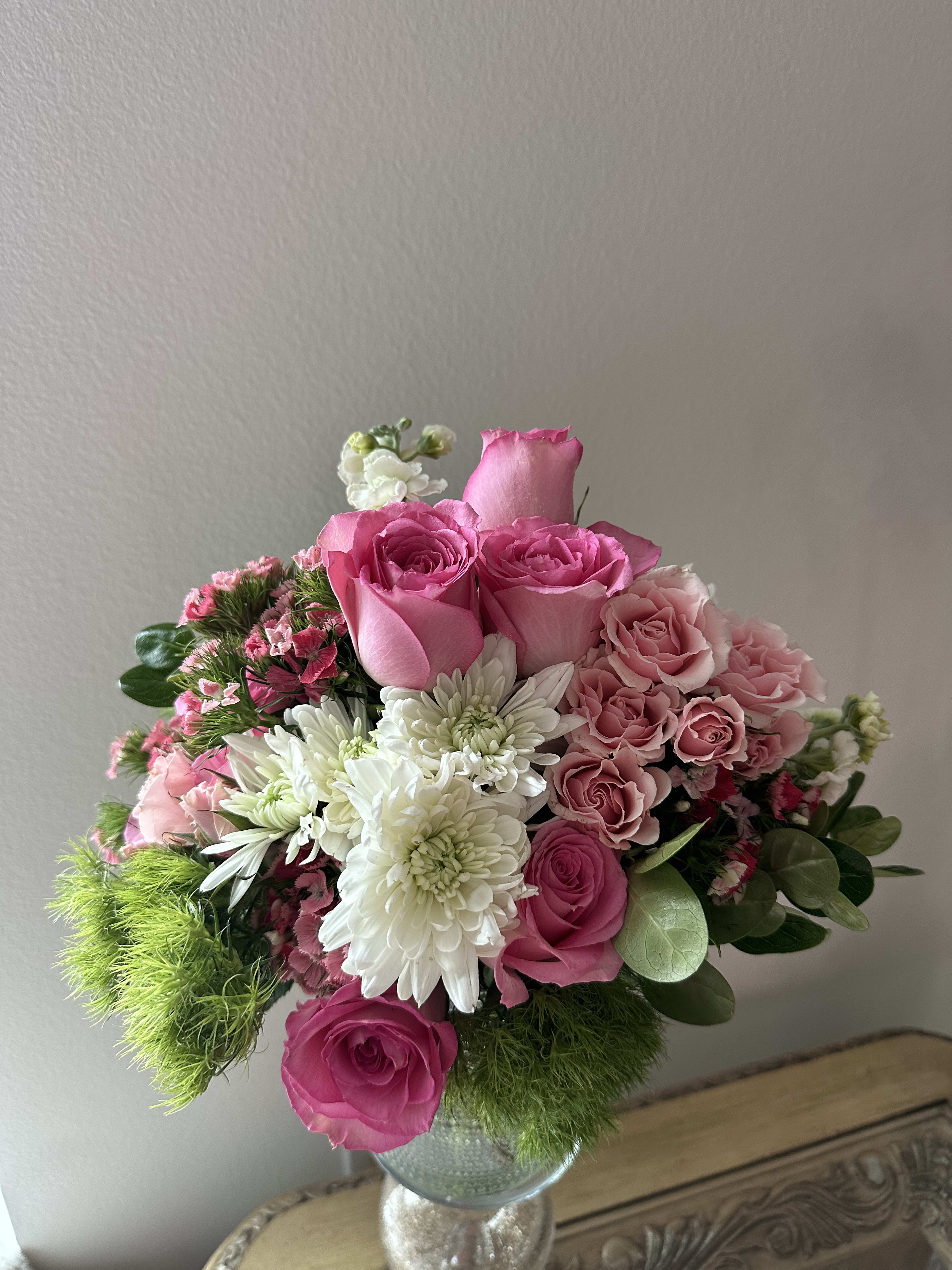 Pink fusion - Hot pink roses, light pink spray roses, and a mix of white mums with beautiful greenery that brings smile to your face every time you look at it!