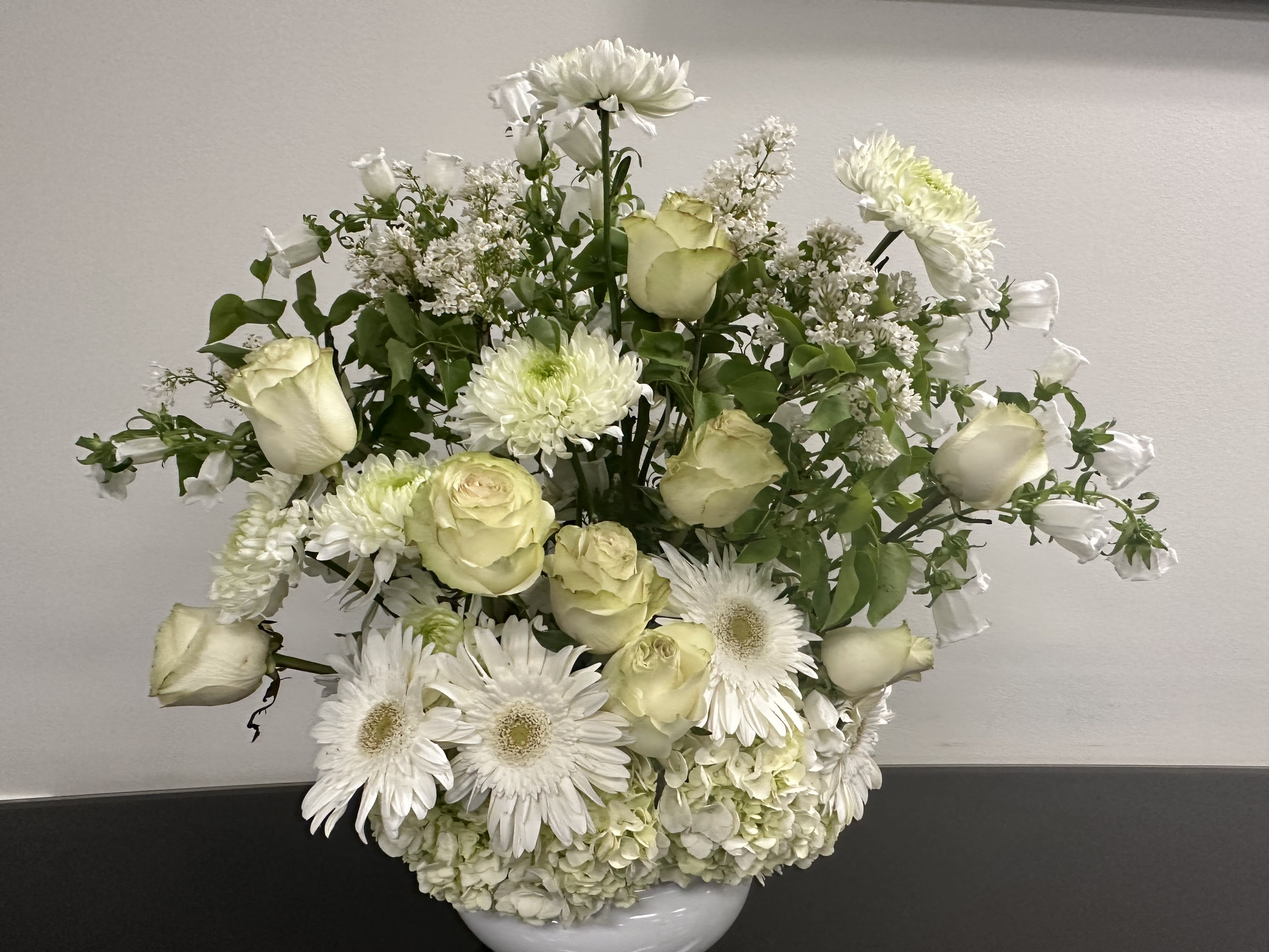 harvest of memories harvest of memories - A gorgeous combination of white lilac, white, Gerbera daisies, green roses, white chrysanthemums, white bells of Ireland, on a bed of white hydrangeas