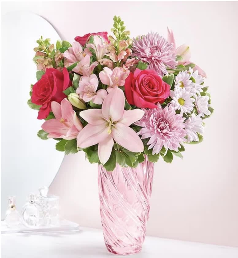 Sweet Embrace  - A lifetime of hugs with our beautiful bouquet. A mix of blooms in shades of pink and lavender is designed in our exclusive petal pink vase, with cascading spiral detail for elegant and timeless style. More than just a vase, it’s a stylish keepsake to cherish over time. This unique gift to make every mom feel loved, whether you’re celebrating together or across the World. 