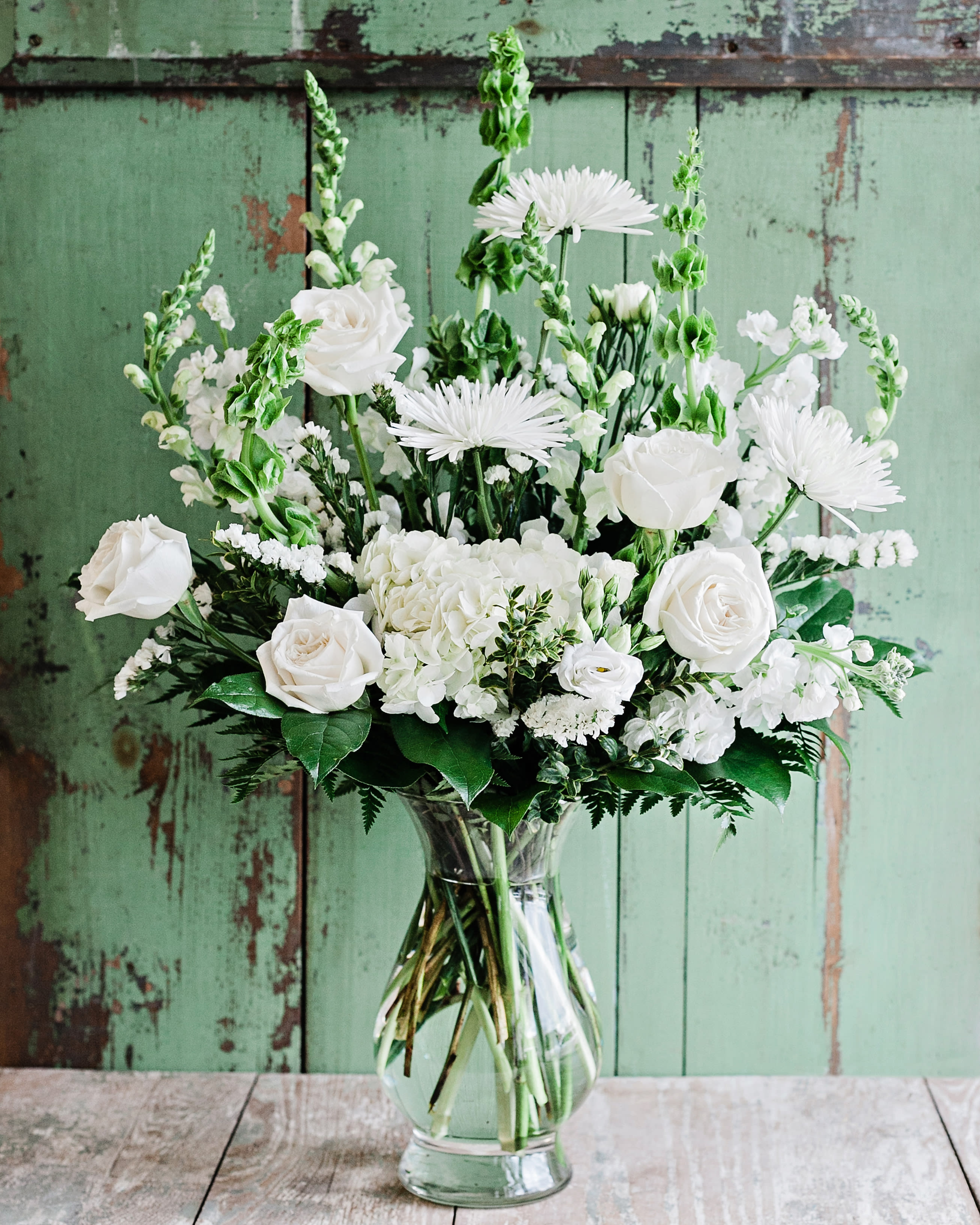 Blanche - A tall vase arrangement full of fresh white flowers such as roses, hydrangea, lisianthus, cremones, snapdragons and stock with accents of green. The orientation of this arrangement is one sided. Approximately 30&quot; tall x 20&quot; wide