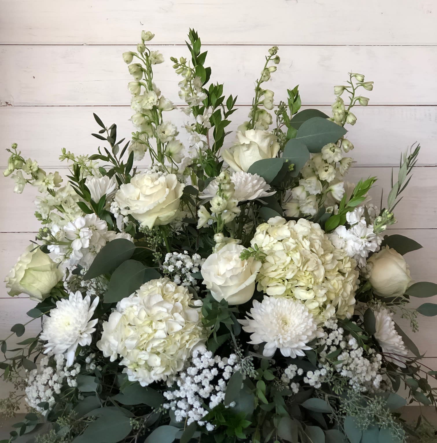 Soft Sympathy - large arrangement in all white tones, flowers may vary with availability. We will do our best to retain the look and feel of the arrangement ,Funeral arrangements require a lead time of two to three days 