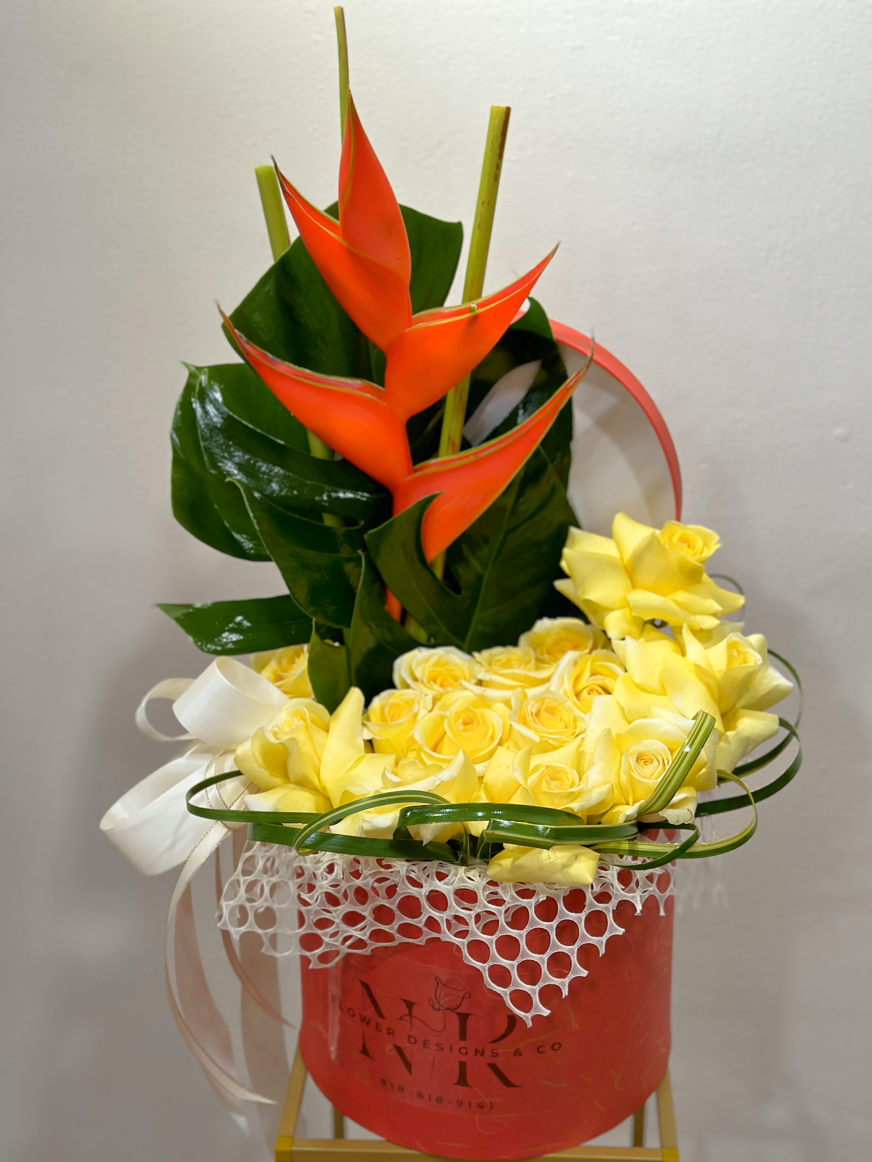 Tropical beauty surrounded by roses! - This bright Heliconia flower adds character to this arrangement. It is surrounded by 15 large roses and finished up with beautiful greenery!