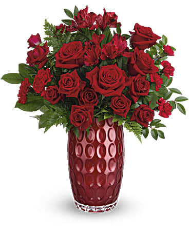 Geometric Beauty Bouquet - Teleflora's Geometric Beauty Bouquet features red roses, red spray roses, red alstroemeria, red carnations and miniature red carnations arranged with huckleberry, leatherleaf fern and lemon leaf. This Valentine's Day bouquet is delivered in Teleflora's Love Always Vase. Approximately 17 3/4&quot; W x 19 1/4&quot; H The scale of the arrangement should determine the type of substitution acceptable, but the substitution must be of equal or greater value and must maintain the style and color harmony of the original order.