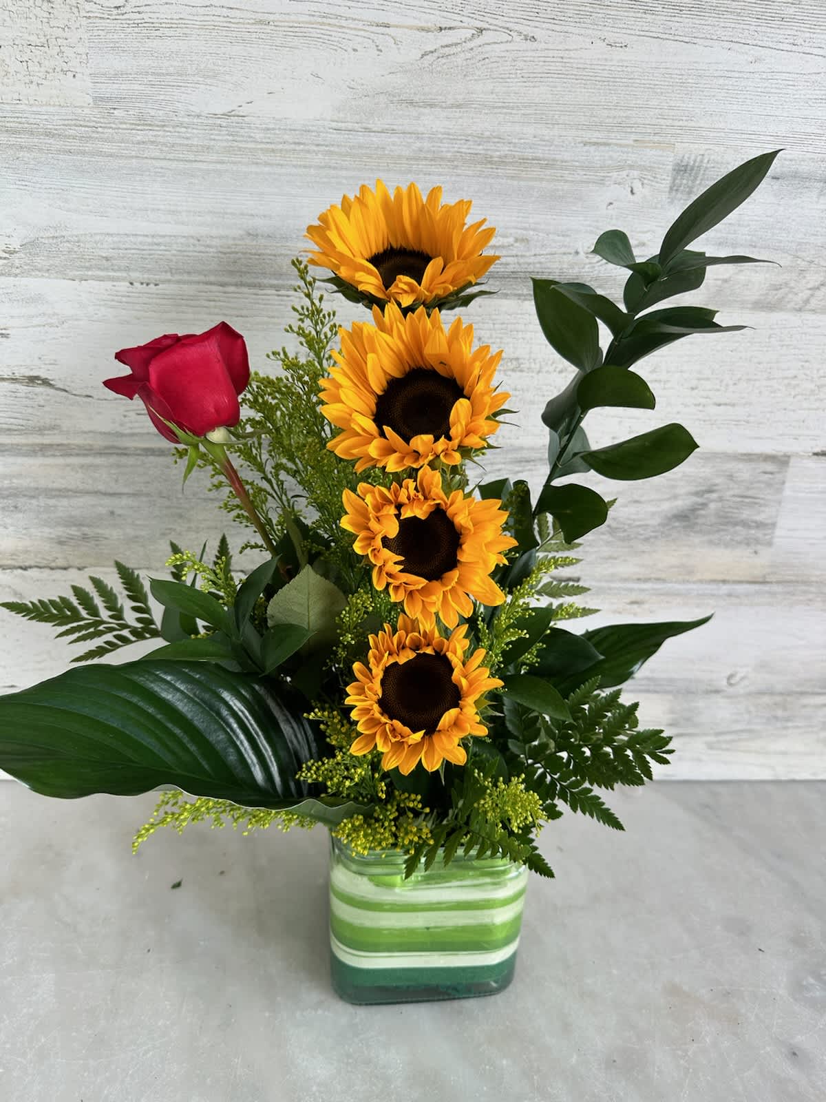 Sunrise everywhere! Sunrise everywhere! - 4 sun flowers design with red rose and curly willow in a glass cube,