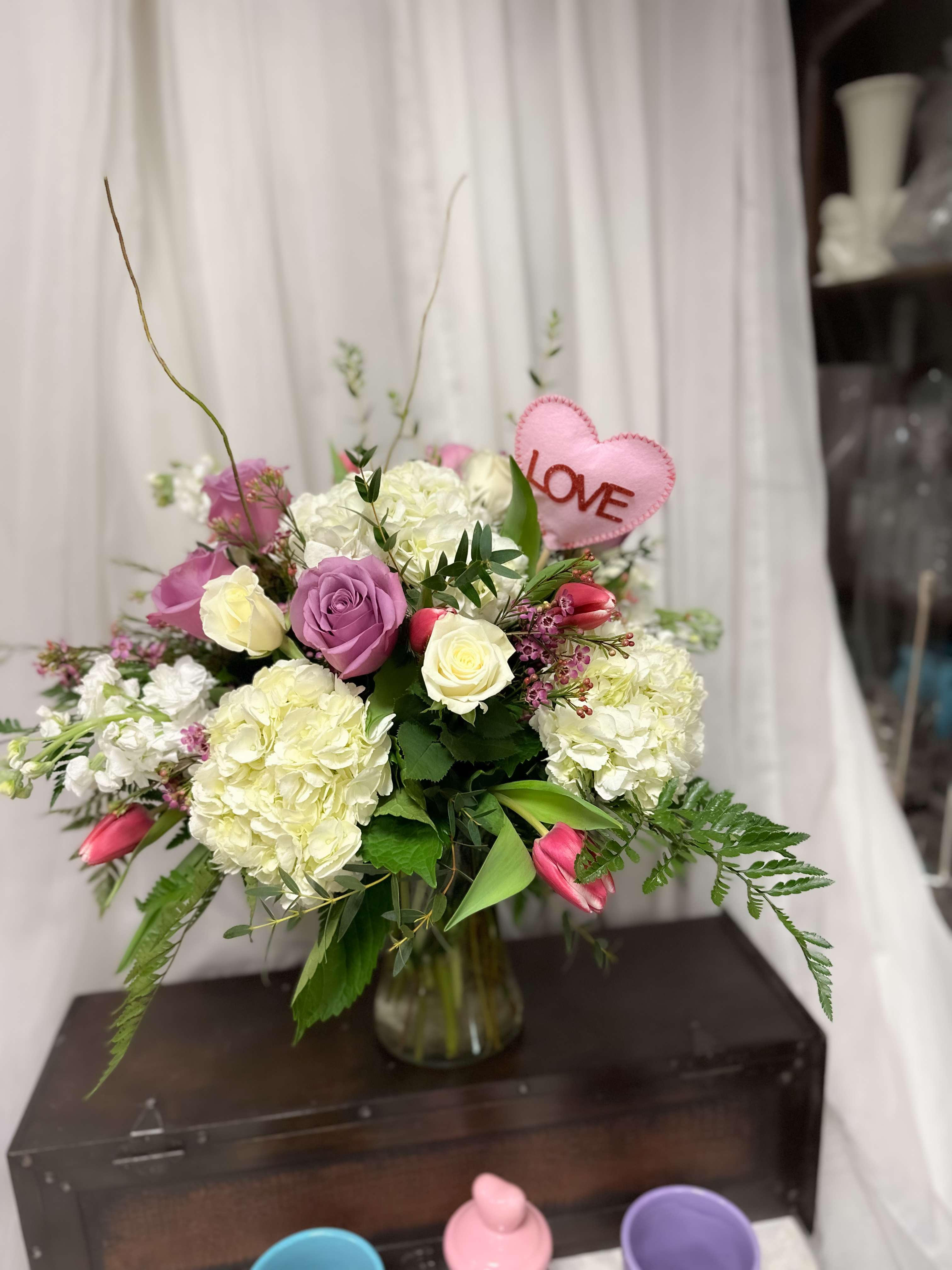 Passionate Bloom  - Valentine’s day special featuring a harmonious blend of vibrant roses, delicate tulips, and lush hydrangea. The romantic combination showcases the timeless beauty of roses symbolizing love, complemented by the graceful elegance of tulips and the fullness of hydrangea blooms. This arrangement is a perfect expression of affection and admiration.