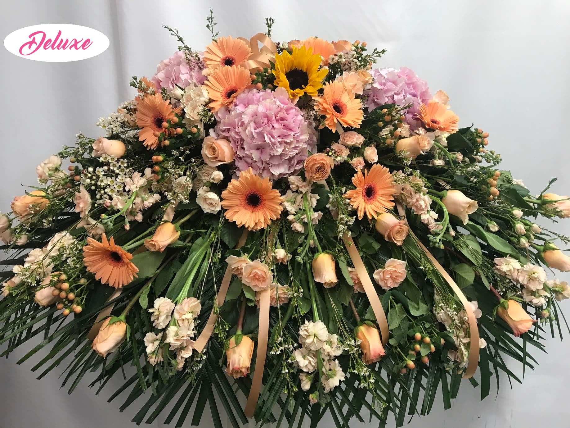 Sweet Peaches Casket Cover Sweet Peaches Casket Cover - What an elegant and sweet casket cover in all peaches and pinks. Very elegant and soft in all pastel colored flowers. Hydrangea, Gerber Daisys, Roses, Stock, Berries and Wax flower all come together and compliment each other nicely.