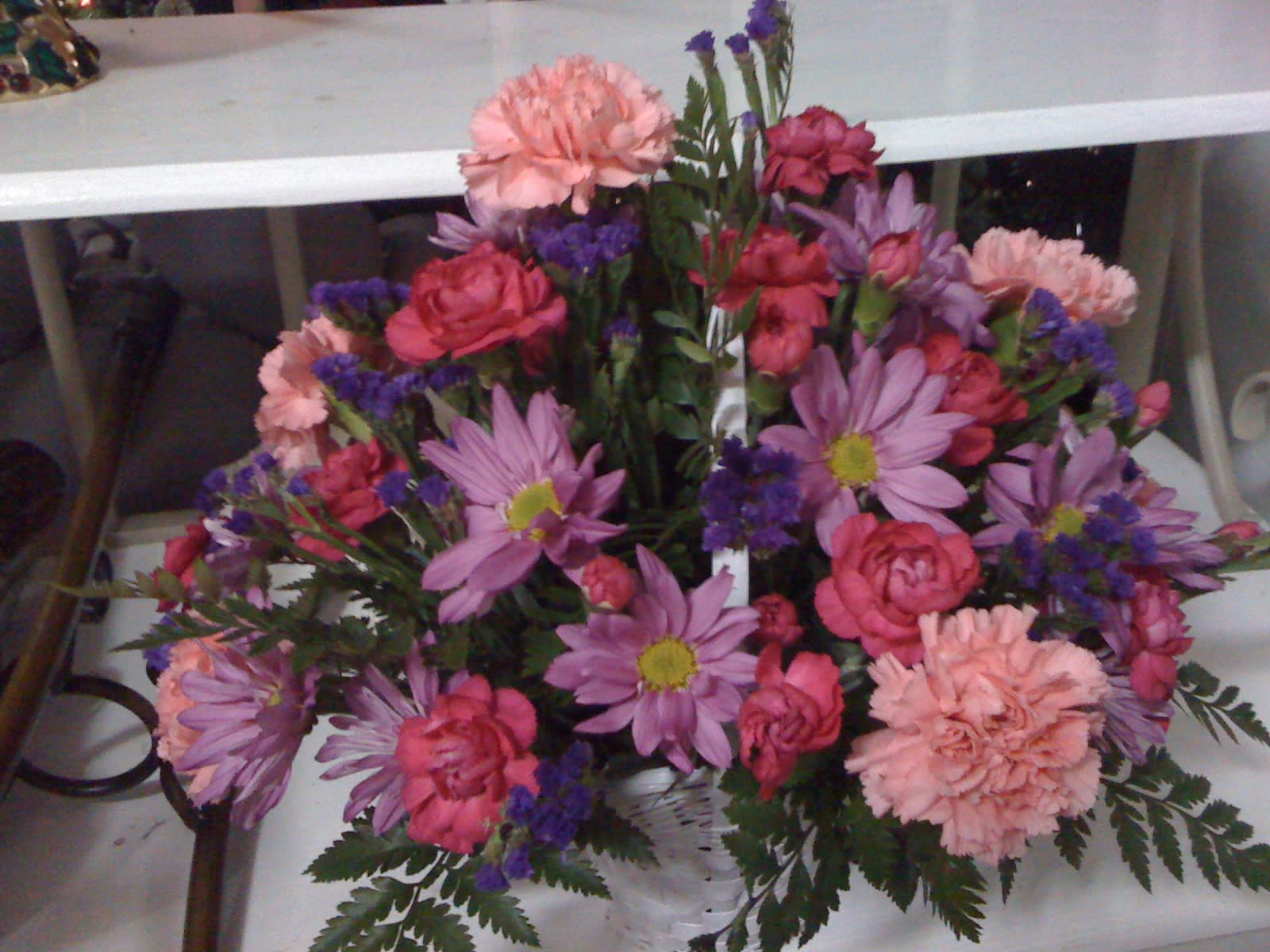 Everyday Flowers - * Pink carnations * Hot pink mini carnations * Lavender daisies * Purple statice * Leather leaf * White basket This cute basket of fun is perfect for those everyday occasions. Birthday well-wishers, fellas in the &quot;dog house&quot;, or &quot;just because you are who you are&quot; occasions are the perfect times to send this basket.  Colors and flower types may vary based on stock.