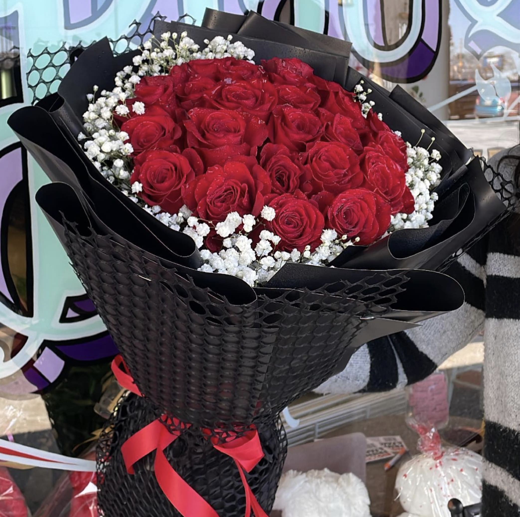 Red Roses Wrapped In Black Paper Red Roses Wrapped In Black Paper - 1. Elevate your gift-giving game with a stunning arrangement of crimson roses elegantly enveloped in sleek, jet-black wrapping. This unique combination of vibrant red blooms and sophisticated packaging creates a striking contrast that is sure to captivate the recipient's attention. The velvety petals of each rose exude passion and love, while the dark paper adds a touch of mystery and intrigue. Whether it's a romantic gesture or a thoughtful gesture for a special occasion, this red rose bouquet wrapped in black paper is guaranteed to make a lasting impression.