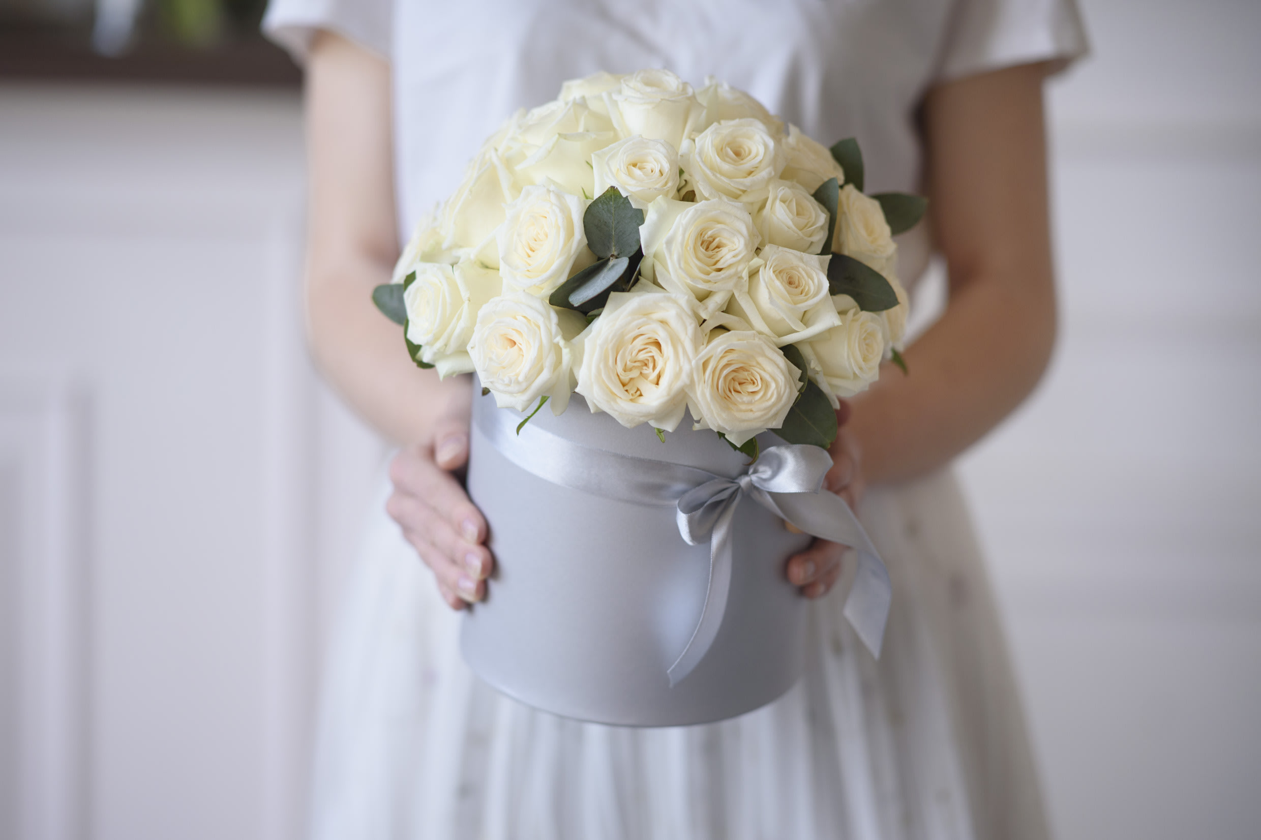 Joan - The Joan arrangement delivery includes: Premium, equadorian white roses (up to 30 - medium sized box, up to 50 - large sized box) accented with eucalyptus (Color may vary) Your custom message on our Luxe stationary Hat box size: Medium - D8.5H4.5', Large - D10H6'
