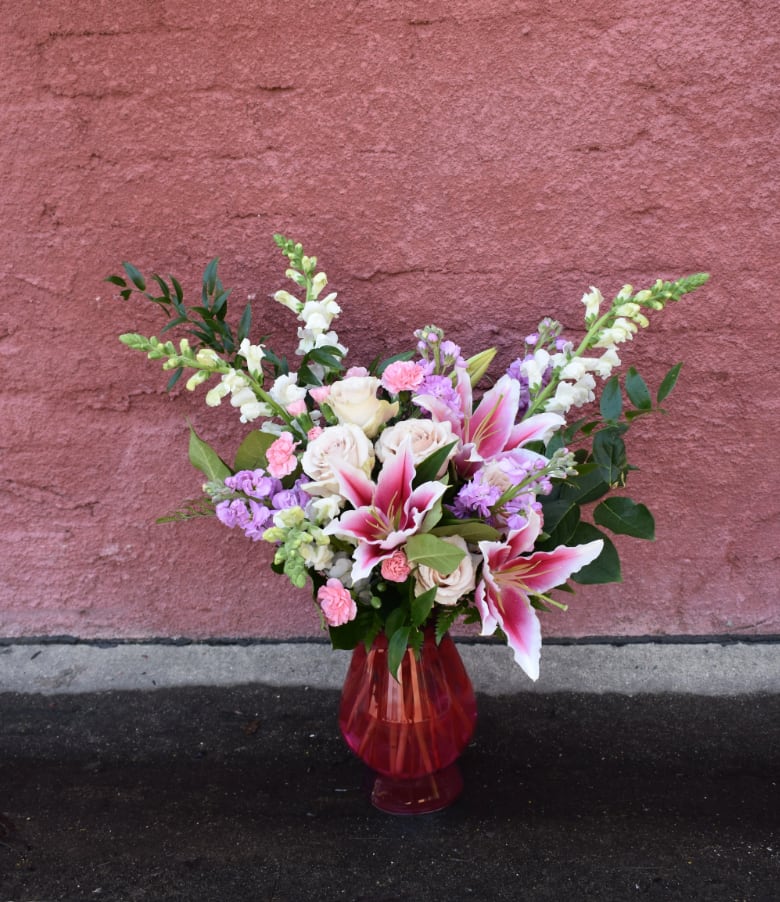 A Moment for Magenta - An exquisite bouquet filled with magenta, white, and hot pink blooms. Lilies, roses, snapdragons, and stock are designed beautifully in a magenta-toned glass vase.  Perfect for any occasion! 