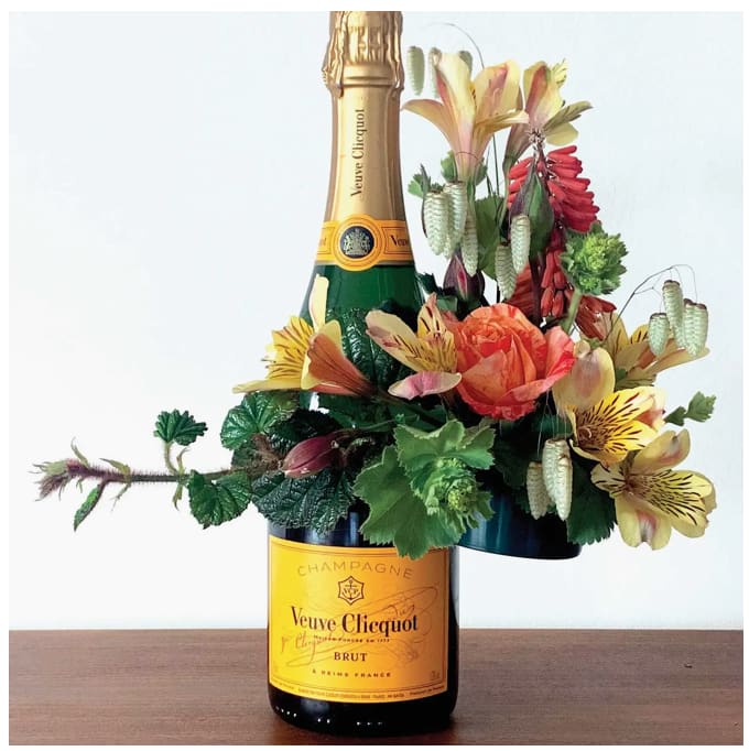 Veuve Clicquot with a beautiful side Piece of flowers - What girl doesn't love some Bubbles Especially Veuve!!!!  Make her smile and you know what they say about champagne...&quot;Makes you Dance and Prance and...&quot;