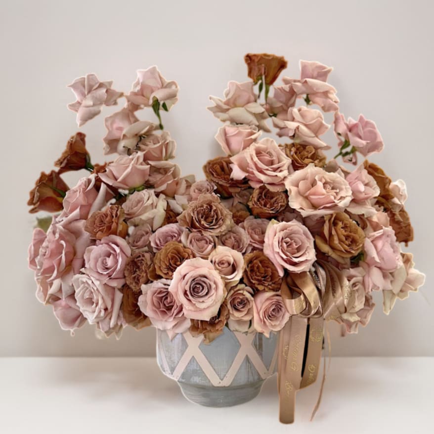 Petal Frappe Petal Frappe - A mash of carefully selected quicksand & toffee roses, sitting on an artistic pink & gray ceramic vase.