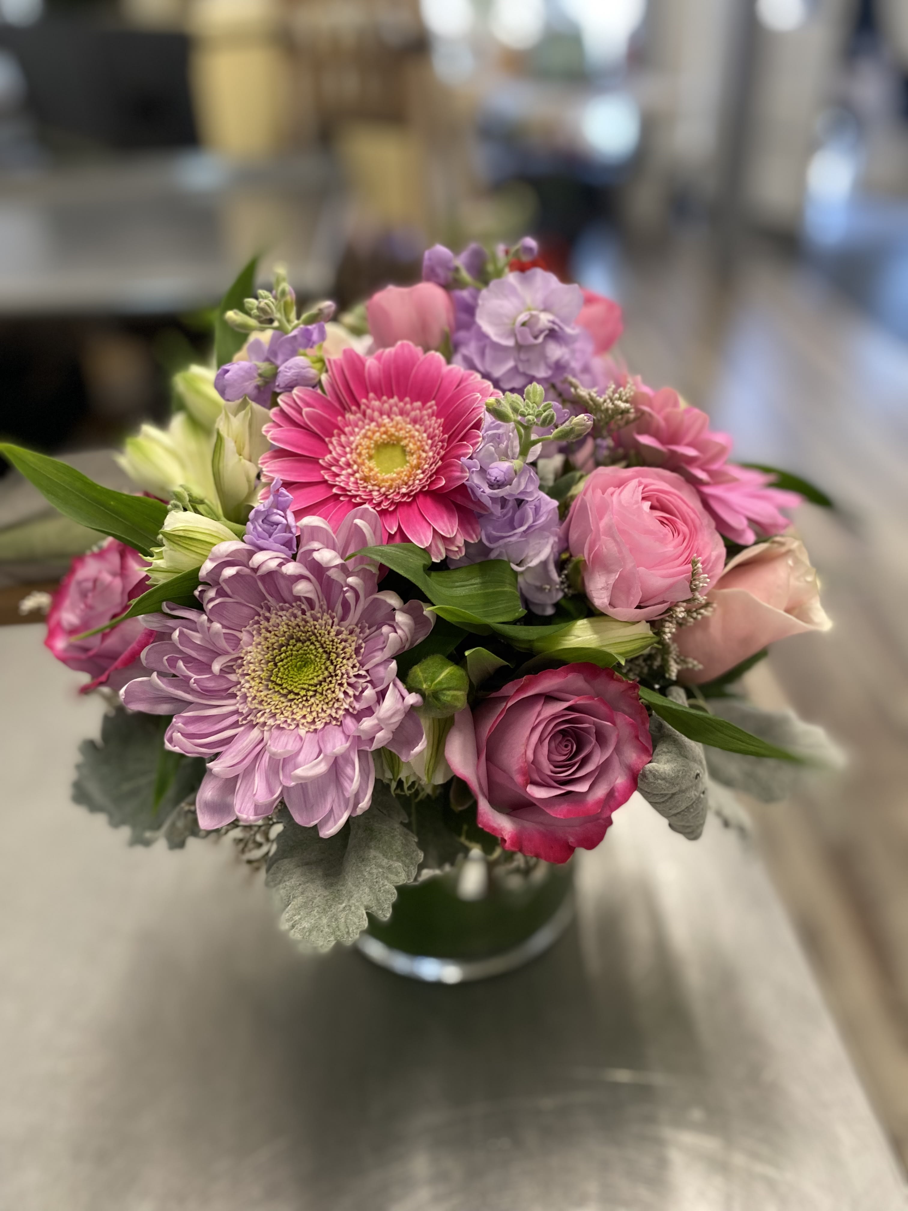 Springtime please Springtime please - A wonderful mix of spring flowers. Gerbera daisies, mums, roses, hydrangea, stock, alstromeria and dusty miller designed in a glass vase. Version shown is the deluxe.