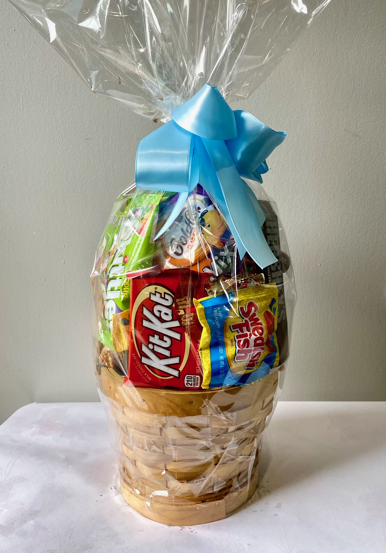 Sweets Basket - For the one with a sweet tooth, this gft basket has an exciting mix of candies and chocolates, wrapped and tied with a bow. 