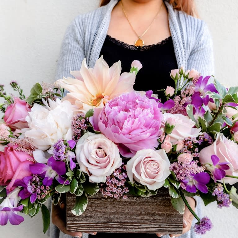 Pastel Elegance - The pastel palette is the inspiration behind the design for “Pastel Elegance”! Ranging from soft blush of roses and serene lavender orchids, this bouquet adds an ethereal quality creating an impressive space that transcends the ordinary.   Approximately 16” W x 9” H