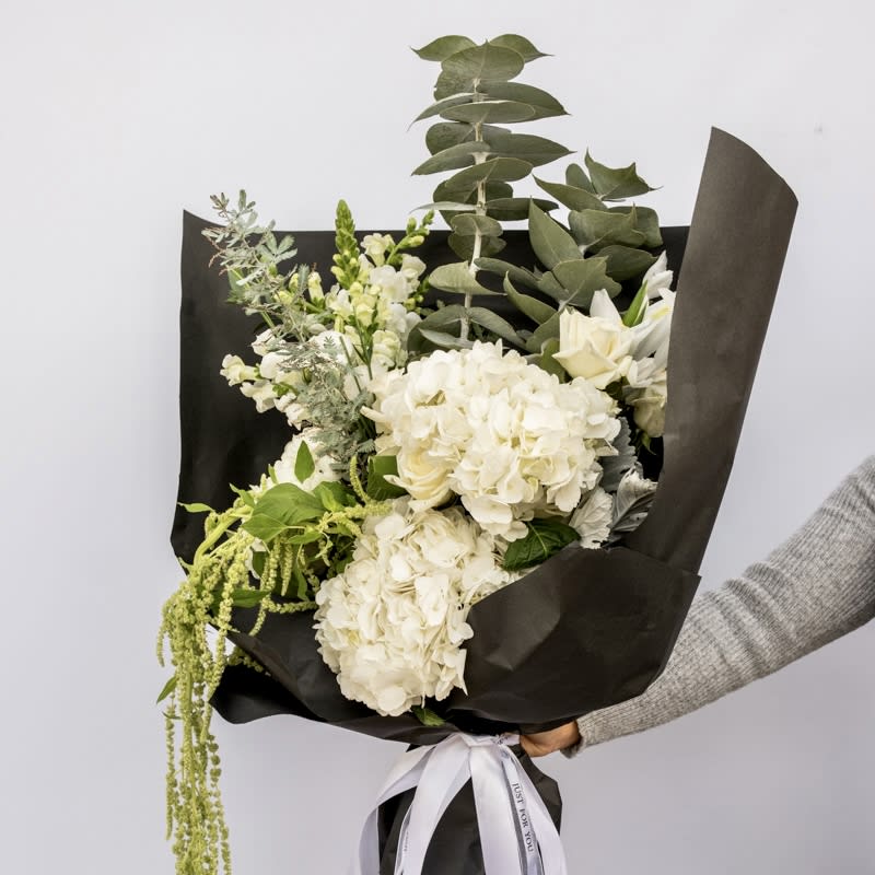 Elegant White - Elegance in every petal! Introducing our Elegant White hand-tied bouquet featuring a symphony of all-white flowers carefully curated and designed to impress!   Perfect for all occasions!  Approximately 18” W x 22” H