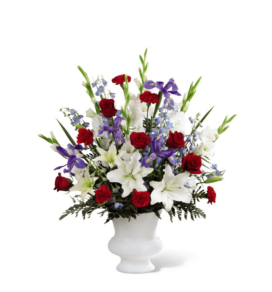 Gratitude™ Arrangement Gratitude™ Arrangement - A dramatic floral salute respectfully features a heroic color palette of red, white and blue to honor the life of a hero. Our Gratitude™ Arrangement is designed with lilies, irises, delphinium and roses to share your sympathies with reverence and respect. While the lilies may initially arrive in bud form, they beautifully transform as they open. Details: o Good arrangement is approximately 32"H x 26"W o Better arrangement is approximately 35"H x 29"W o Best Arrangement is approximately 36"H x 30"W