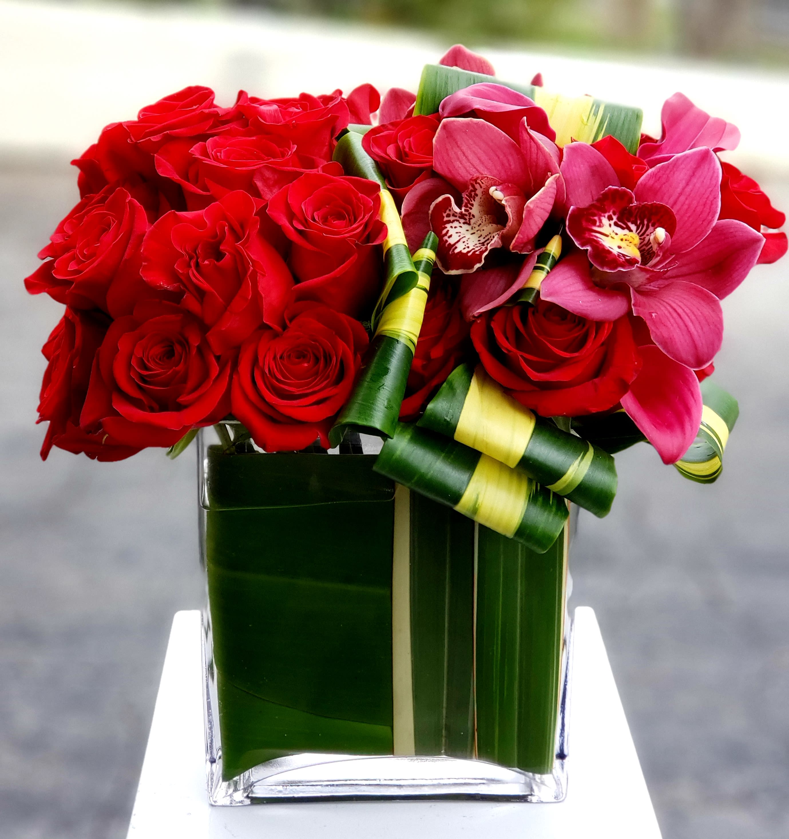 Red roses for Amor Mio - Paint L.A. Red with Passion: Roses, Orchids, Green Whispers (Santa Monica, Hollywood, Pasadena, Beverly Hills, West Hollywood) Forget whispered confessions this Valentine's Day in Los Angeles! Dave's Flowers invites you to paint the town crimson with a declaration of adoration as bold as the city lights. Imagine a vibrant tapestry of fiery red roses, their velvety petals radiating the color of love itself, entwined with majestic cymbidium orchids, their delicate beauty adding a touch of elegance. To complete the passionate symphony, fresh green accents weave a whisper of intrigue, transforming any room into a love story masterpiece. This isn't just a bouquet; it's a love proclamation bursting with color, ready to ignite a wildfire of romance in your sweetheart's heart.  More Than Just Vibrant Hues:  L.A.'s Love Volcano: Our skilled florists are love's pyrotechnicians, handcrafting each arrangement into a breathtaking eruption of passion. Prepare for gasps of awe and declarations of &quot;forever&quot; when you unveil this captivating declaration. Locally-Sourced Radiance: We hand-pick only the freshest, most vibrant blooms from trusted L.A. growers, ensuring long-lasting brilliance and intoxicating fragrances that linger like whispered promises in the evening breeze. Beyond February 14th: Rekindle the fiery flame anytime! This versatile masterpiece shines on anniversaries, birthdays, or simply as a reminder that your love burns brighter than the Hollywood spotlights. Blooming Convenience for Busy Angels:  Skip the L.A. traffic and let love blossom at your doorstep. We offer convenient flower delivery across Santa Monica, Hollywood, Pasadena, Beverly Hills, and West Hollywood with same-day or scheduled options. Speak Beyond Words: Let this captivating bouquet do the talking for your heart. Add a personalized message to make your gift even more special and ignite a dance of joy in your loved one's eyes. Sustainable Love Stories: We're committed to eco-friendly practices, sourcing our flowers responsibly to ensure your love story blossoms beautifully for the planet too. Ready to paint your L.A. romance with an explosion of passion this Valentine's Day? Contact Dave's Flowers today and let our blooming artists craft a vibrant masterpiece that reflects the unwavering intensity and undeniable allure of your love story. Explore our world of blooming volcanoes and make every moment a love sonnet in the heart of L.A.