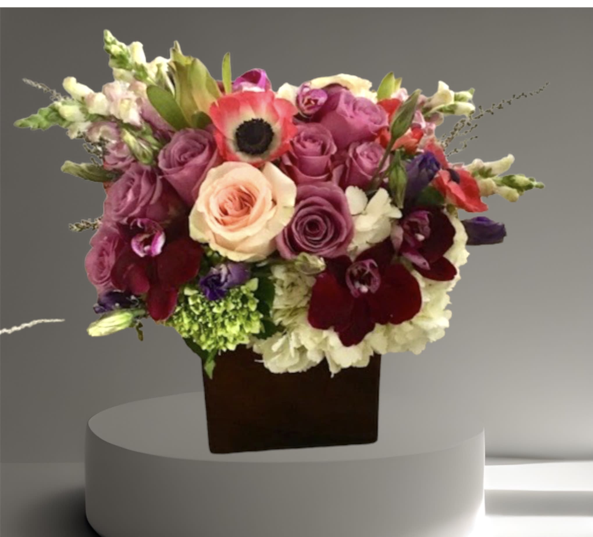 Purple Perfection - A beautiful arrangement in shades of purple and pink. Roses, hydrangea, orchids, snap dragon, and other seasonal flowers/foliage create a dramatic and unique gift.  