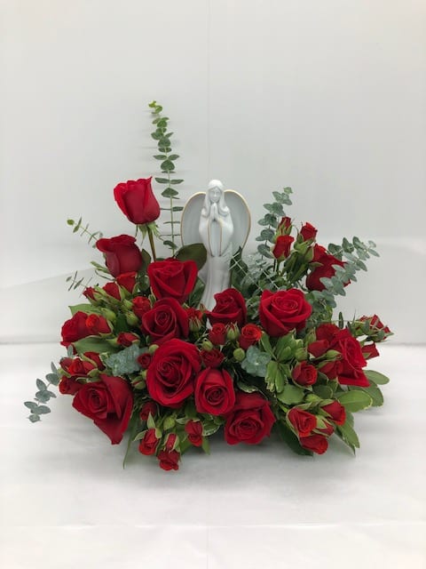 Forever Our Angel Forever Our Angel - This radiant bouquet includes red roses, red spray roses, spiral eucalyptus, variegated pittosporum, and lemon leaf. Delivered with an Angel of Grace Keepsake.