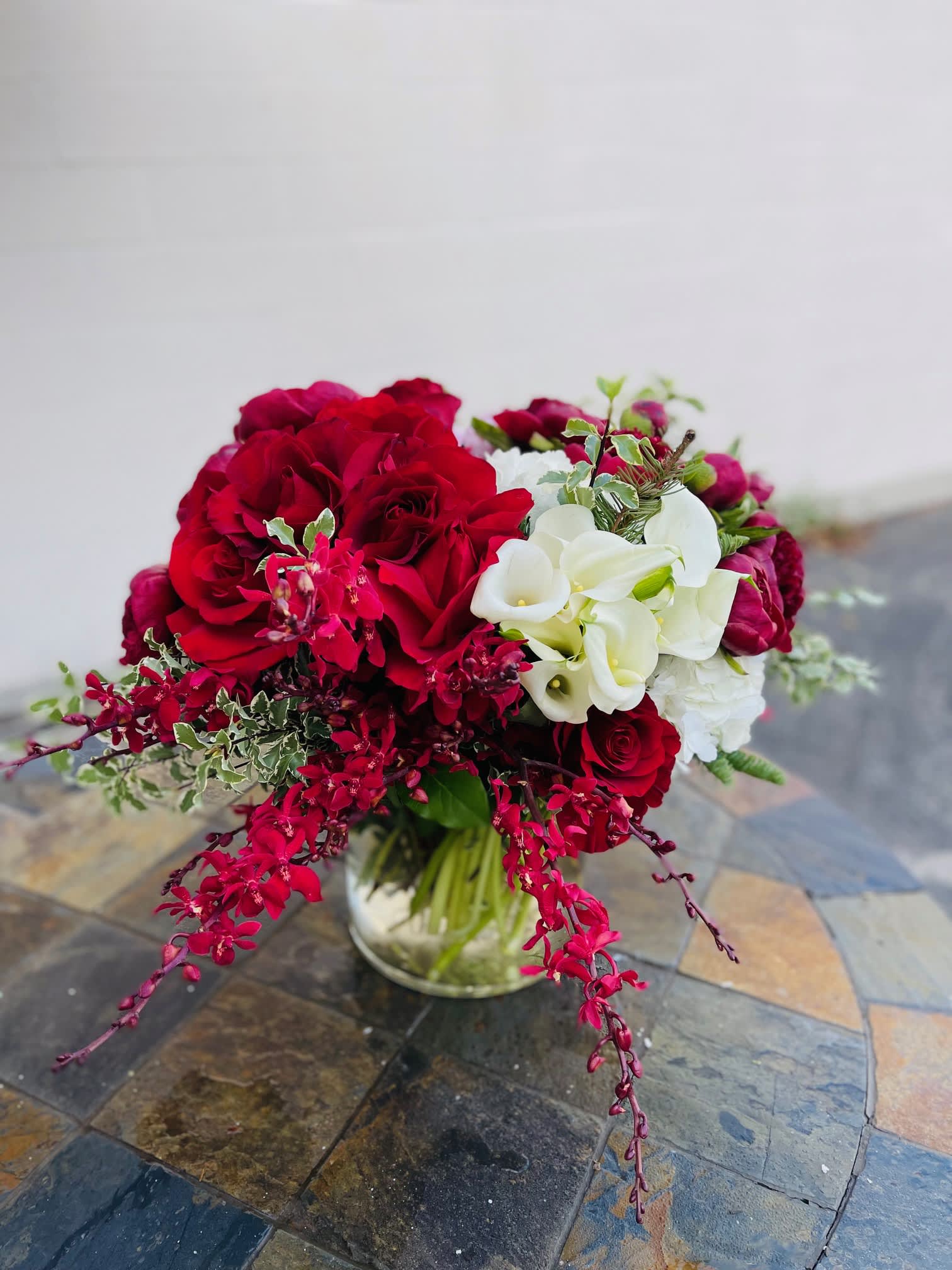 Red rose, red orchids and white African Callalilies - Large 8x12 tall vase with large Red roses, African Callalilies, Hydrangeas, Peonies and orchids. 