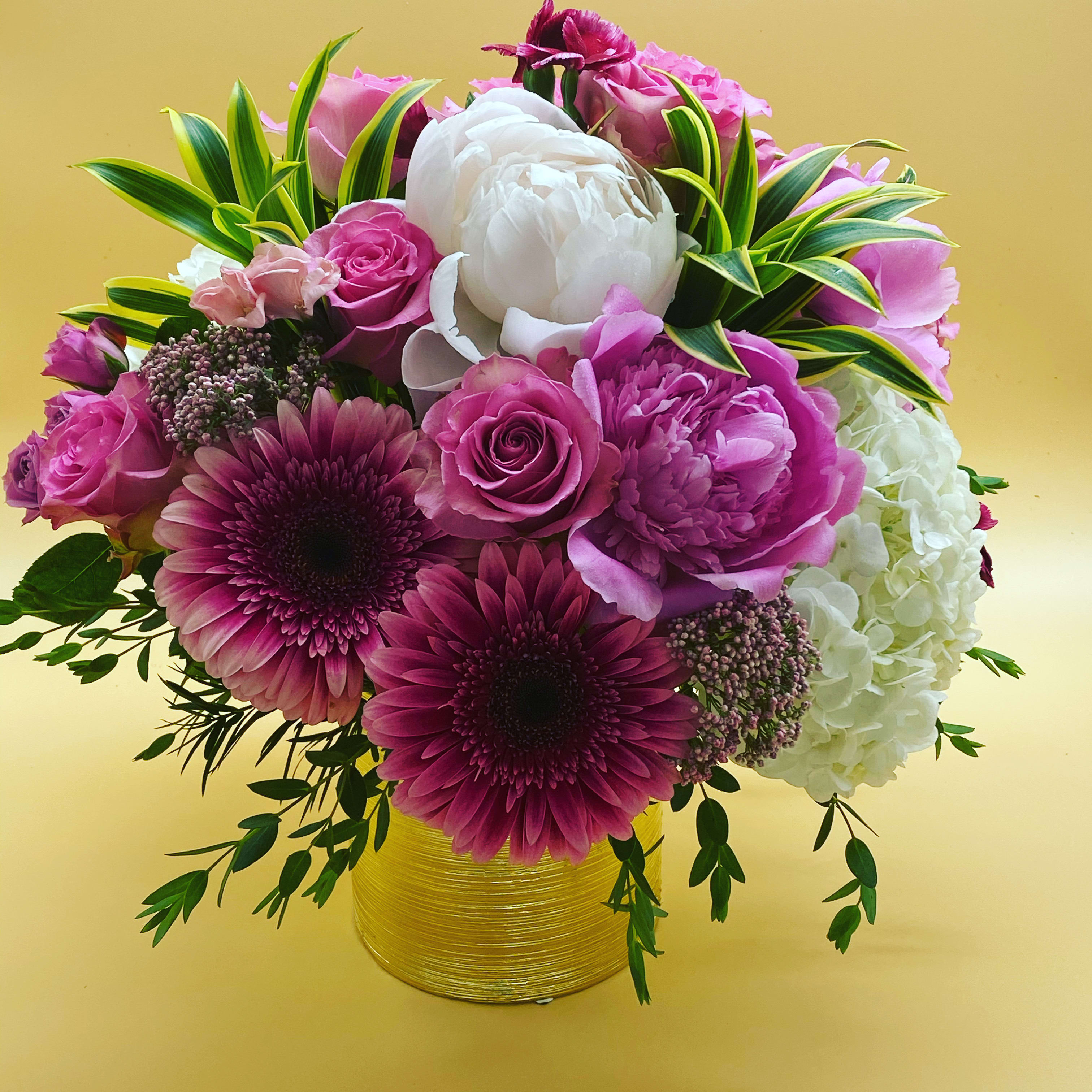Grand Summer Blooms - Peonies are here for such a short time, everyone should have the joy of experiencing these blooms in their own environment.  These are mixed with roses, gerberas and hydrangea.  The variegated foliage of the song of india  highlight the bright, vibrant colors.  These are only here for a short time!!!