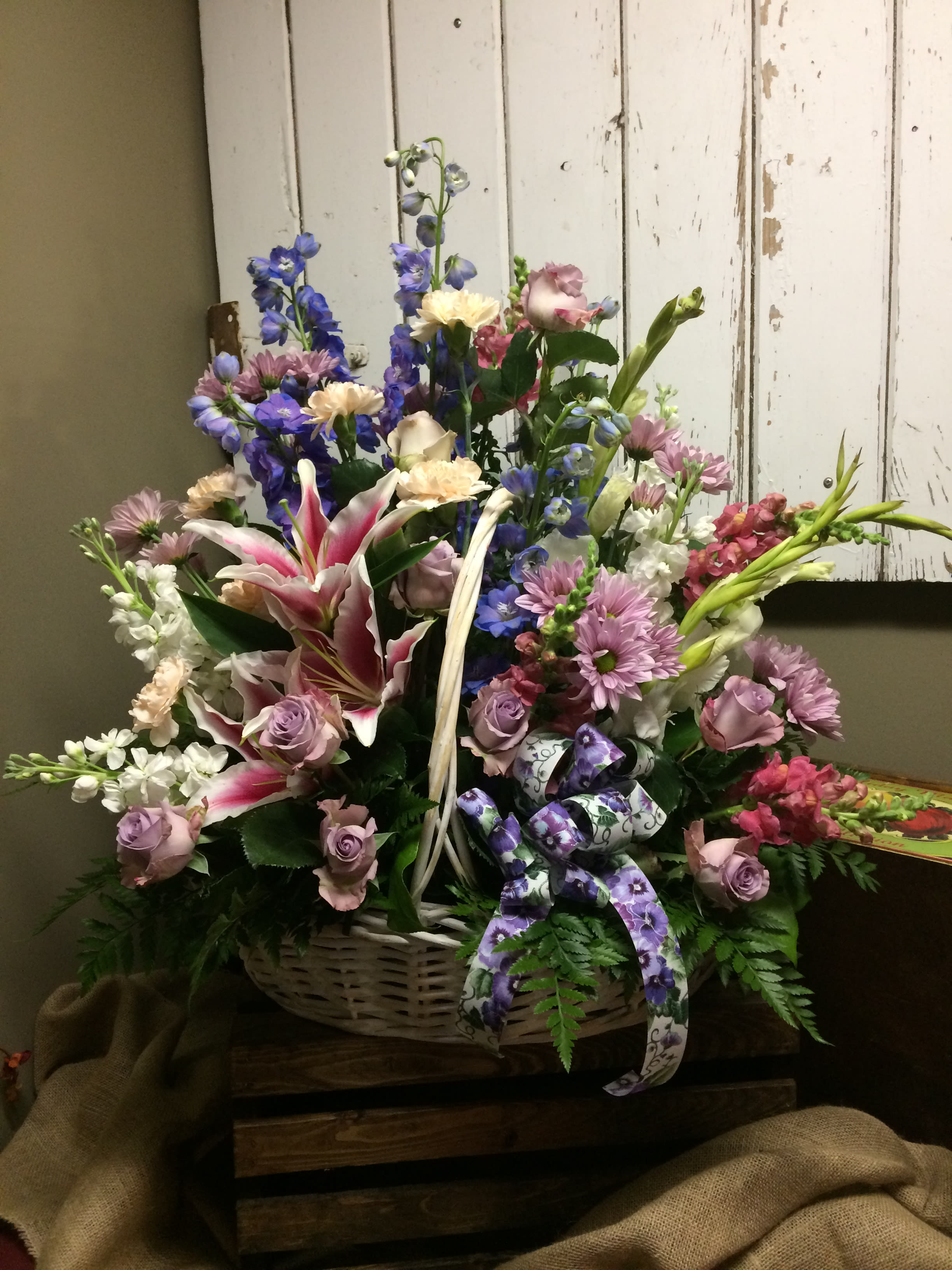  &quot;Beauty&quot; Custom Design by Cold Spring Floral - Thoughtful Beauty is a collection of fresh blue delphinium, cream carnations, lavender roses and daisies, White stock, snapdragons, gladiolas and Stargazer lilies. Artfully arranged in a natural tone basket with fresh mixed greenery. Exact flowers are subject to substitutions due to availability. 