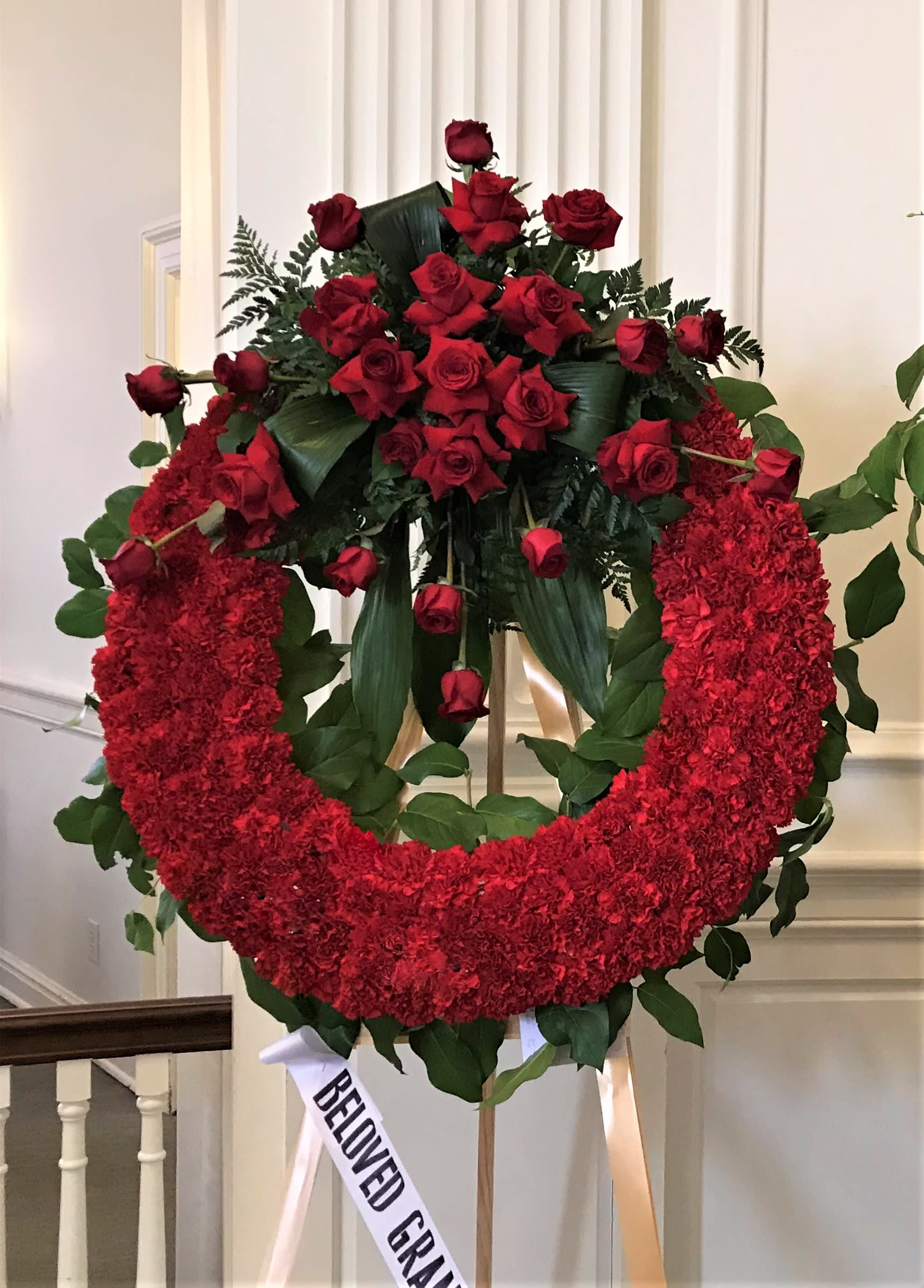 Deep Red Wreath Deep Red Wreath - Designed with carnations and the arrangement includes roses and greenery. This standing wreath comes on a 6ft easel. Colors may be customized, please leave color preference in the special instructions section. Comes in 3 different sizes: 24" - Standard 27" - Deluxe 30" - Premium
