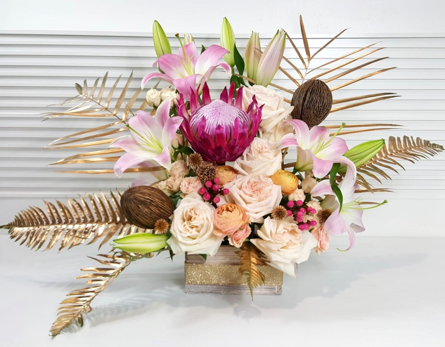 Golden Fantasy - Beverly Hills - Collection of Lillies, Spray Roses, Protea, Ranunculus, Garden Roses, and Coffee Bean in a wooden box vase