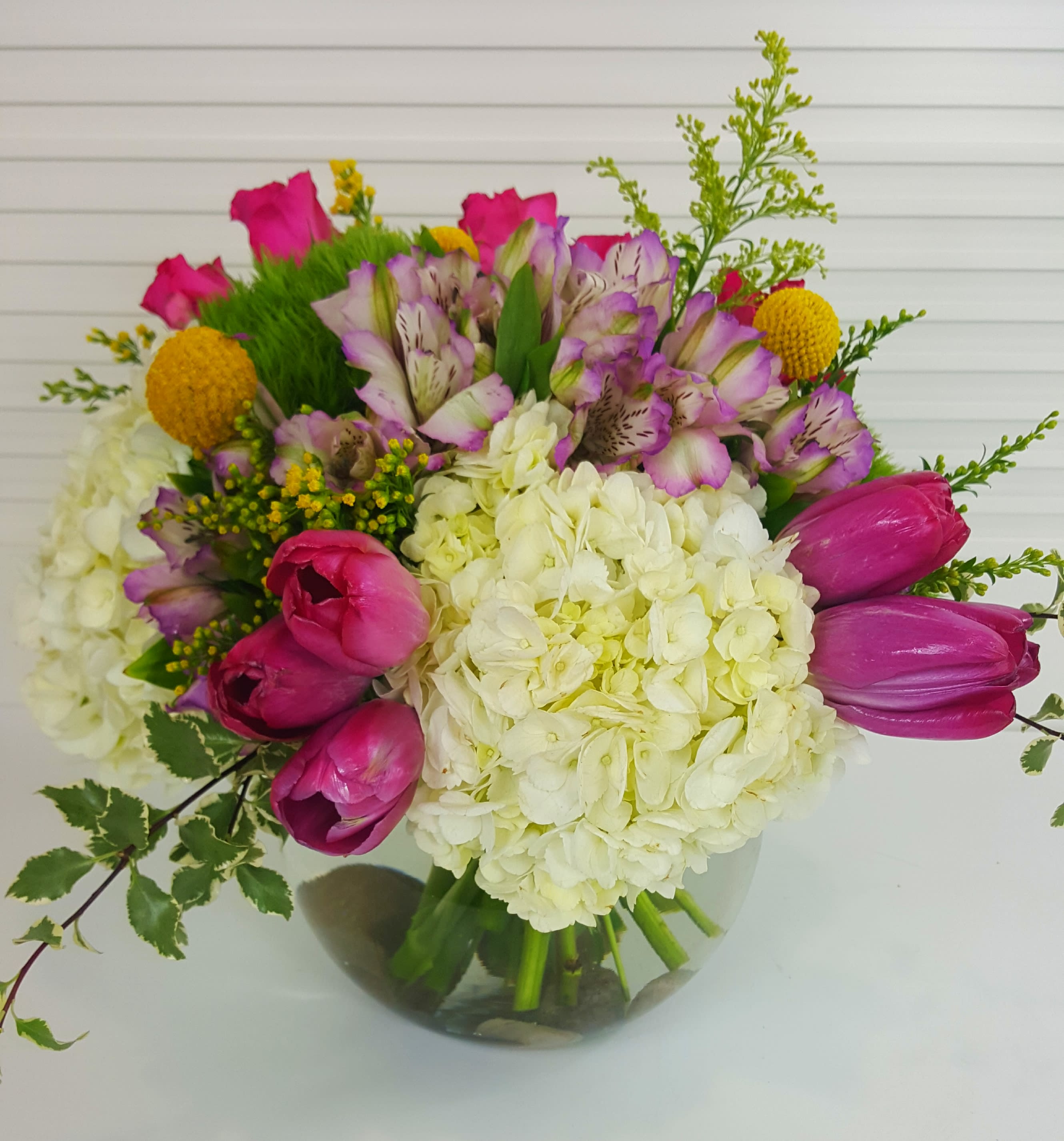 Graceful Beauty - Beverly Hills - Collection of Hydrangeas, Tulips, Roses, Alstromerias and mix of greenery in a clear fish bowl vase.