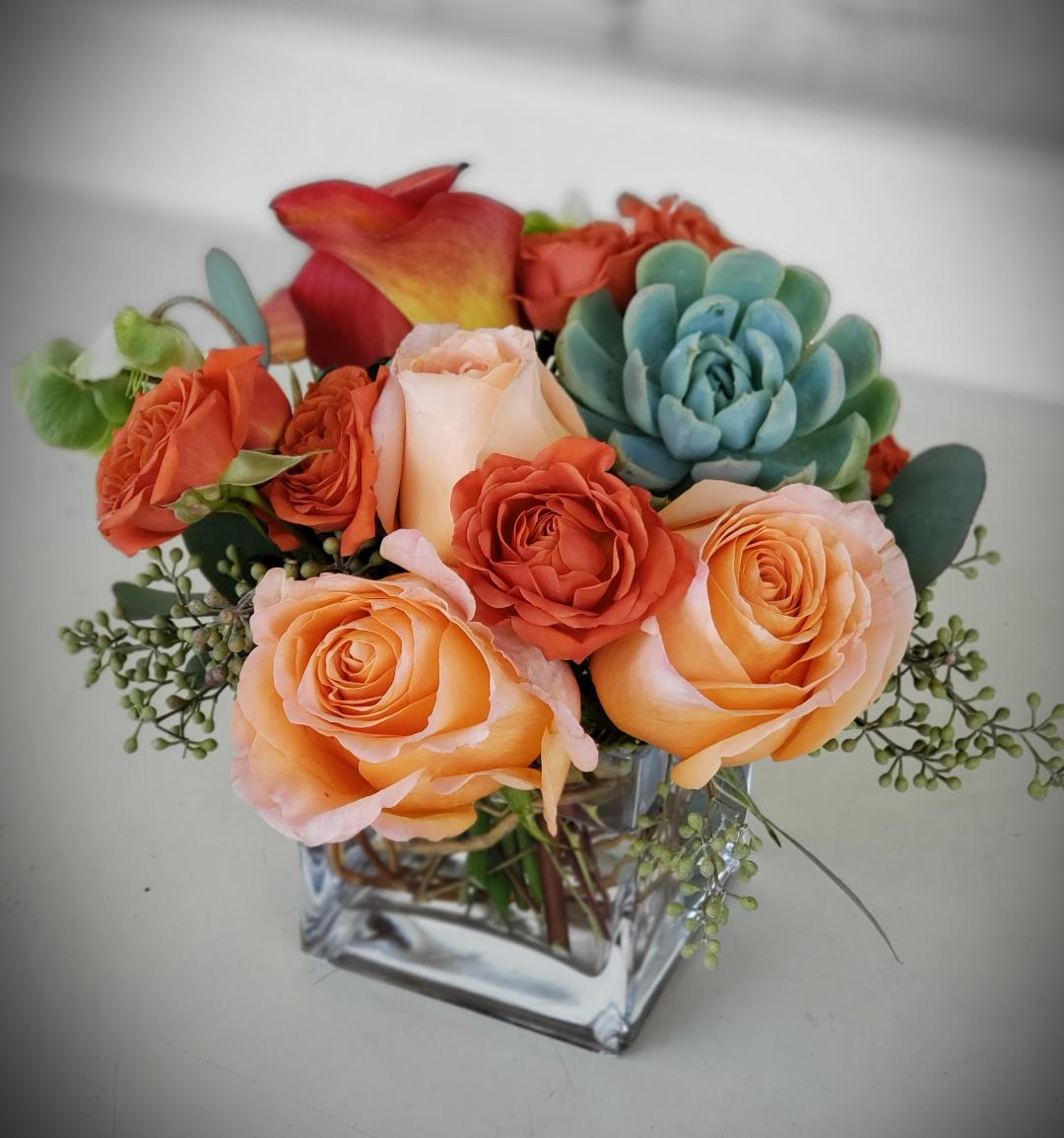 Orange sorbet - Embrace the elegance of Valentine's Day with our exquisite floral arrangement, handcrafted by your trusted florist in Los Angeles, florist in Santa Monica, florist in Hollywood, florist in Pasadena, florist in Beverly Hills, and florist in West Hollywood. This stunning display features a harmonious blend of pastel roses, orange calla lilies, and orange spray roses, accented with beautiful succulents, creating a captivating visual feast.  Crafted to perfection, this arrangement is presented in a vase, adding a touch of sophistication to any space. Whether you're expressing love, gratitude, or admiration, this arrangement is sure to make a lasting impression.  Don't miss out on the opportunity to surprise your loved one with this delightful gift. Order now for flower delivery in Los Angeles, flower delivery in Santa Monica, flower delivery in Hollywood, flower delivery in Pasadena, flower delivery in Beverly Hills, and flower delivery in West Hollywood, and let your affectionate gesture shine this Valentine's Day!
