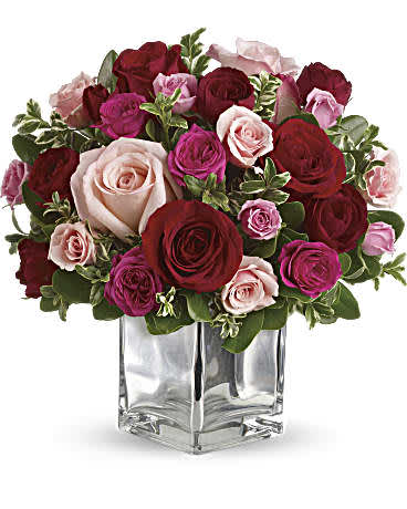 Love Medley Bouquet with Red Roses - Sing them a love song - with flowers. This lush, loving rose arrangement tells them just how much you care. The stylish deluxe bouquet features a generous amount of large red and pink roses accented with smaller spray roses in shades of red and pinks. Delicate green oregonia and pittosporum add a fresh contrast. The flowers are delivered in our exclusive Mirrored Silver Cube vase. Orientation: All-Around