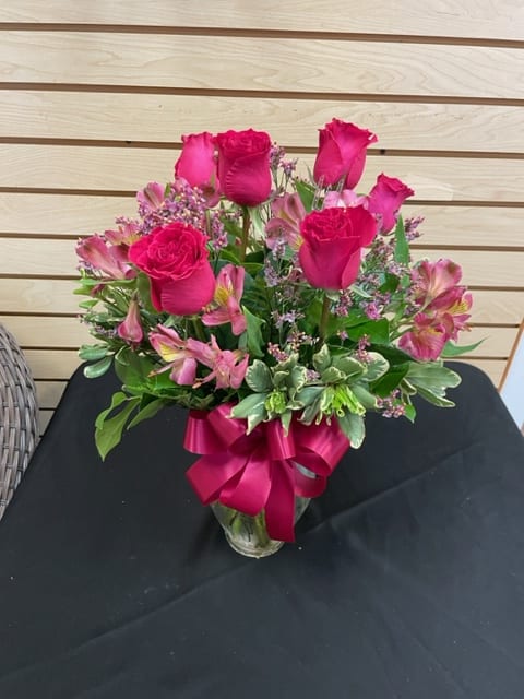 Hot Pink  Splendor - 6 hot pink roses accented with pink alstroemeria, limonium, and greenery in a vase with a bow.