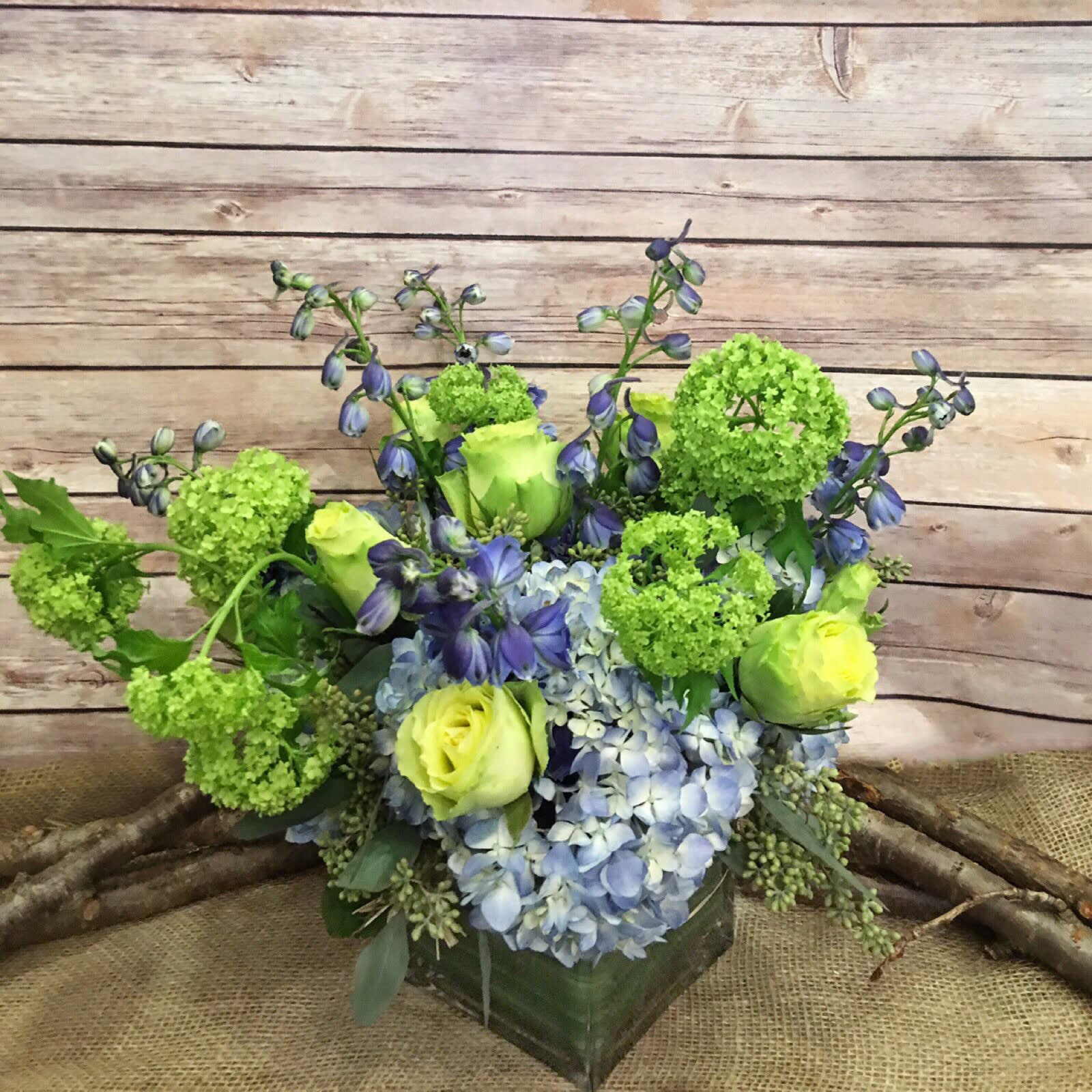 YOU BLUE ME OFF MY FEET - ASSORTMENT OF BLUE HYDRANGEAS, BLUE DELPHINIUM, GREEN ROSES AND VIBURNUM HYDRNGEAS. 