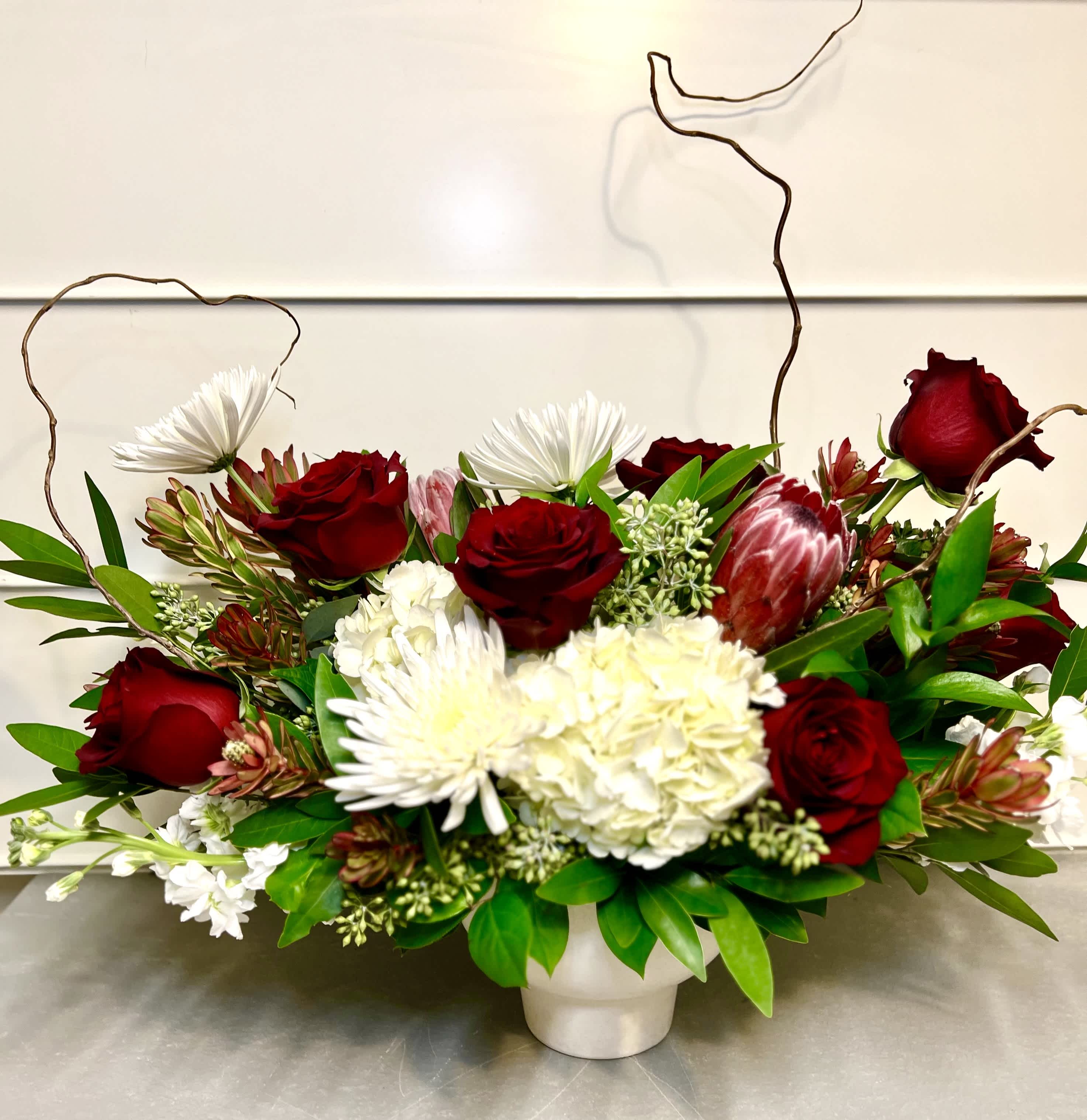 Teddy - This elegant arrangement includes roses, hydrangea, protea, chrysanthemum, leucadendron, stock, and filler with greens.  