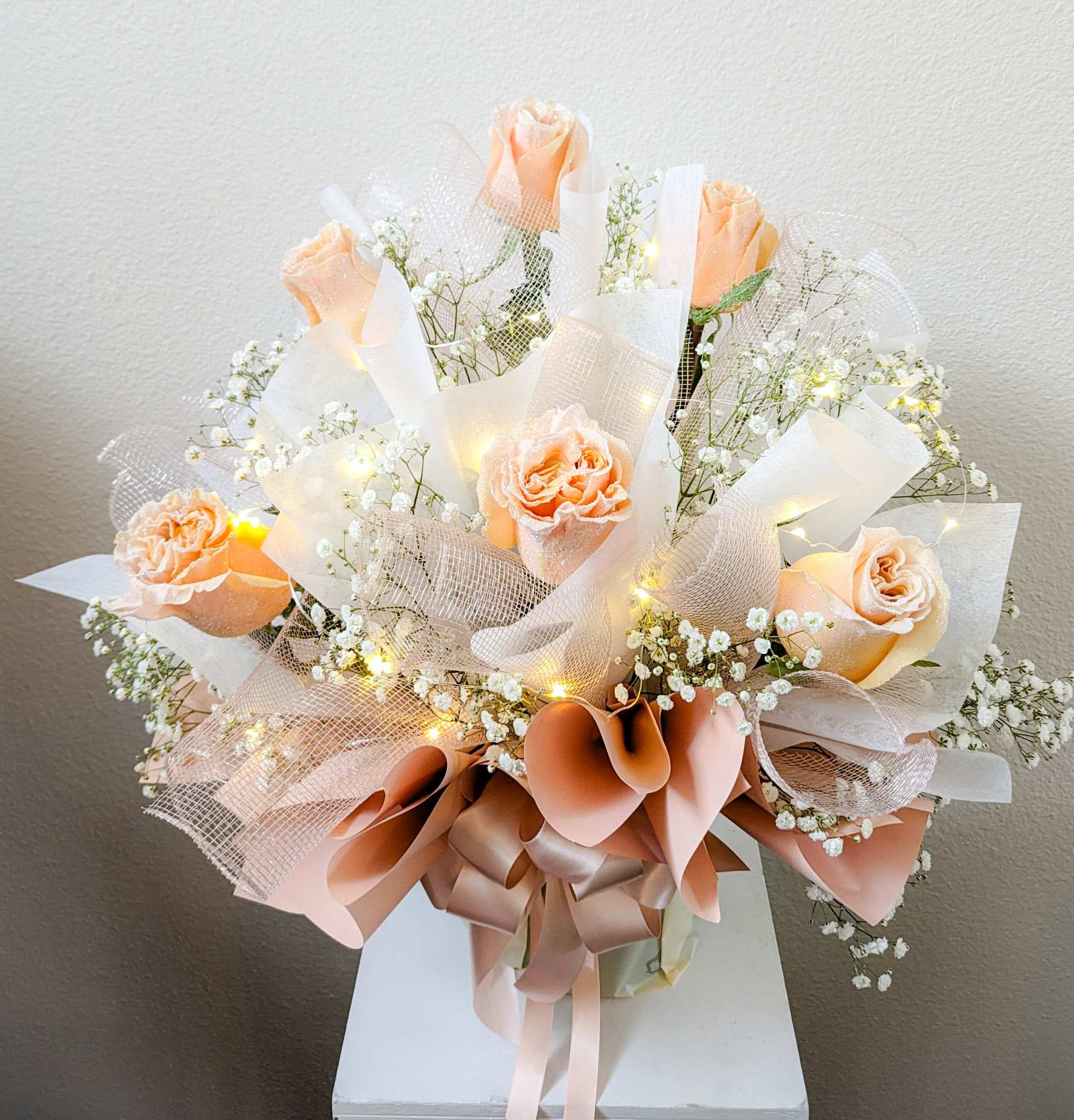 Shimmer  - 1/2 dz. Glittered peach roses wrapped Hong Kong style with LED fairy lights accent.