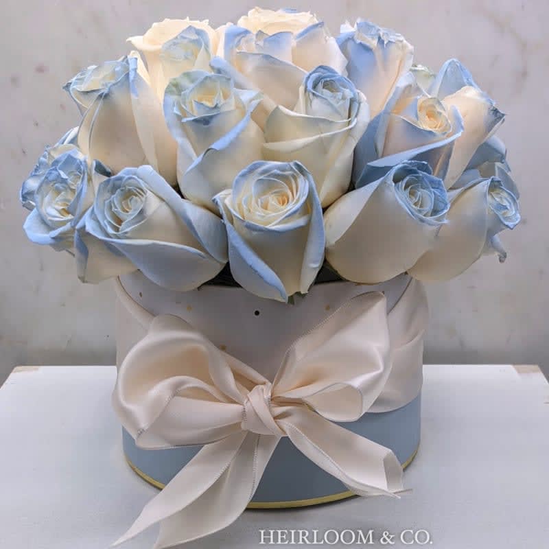 Something Blue Roses - Ingredients: Premium Ivory Roses with a Blue Pastel Accent White Hat-Box with Gold Polka Dots Tied with an Ivory Satin Ribbon