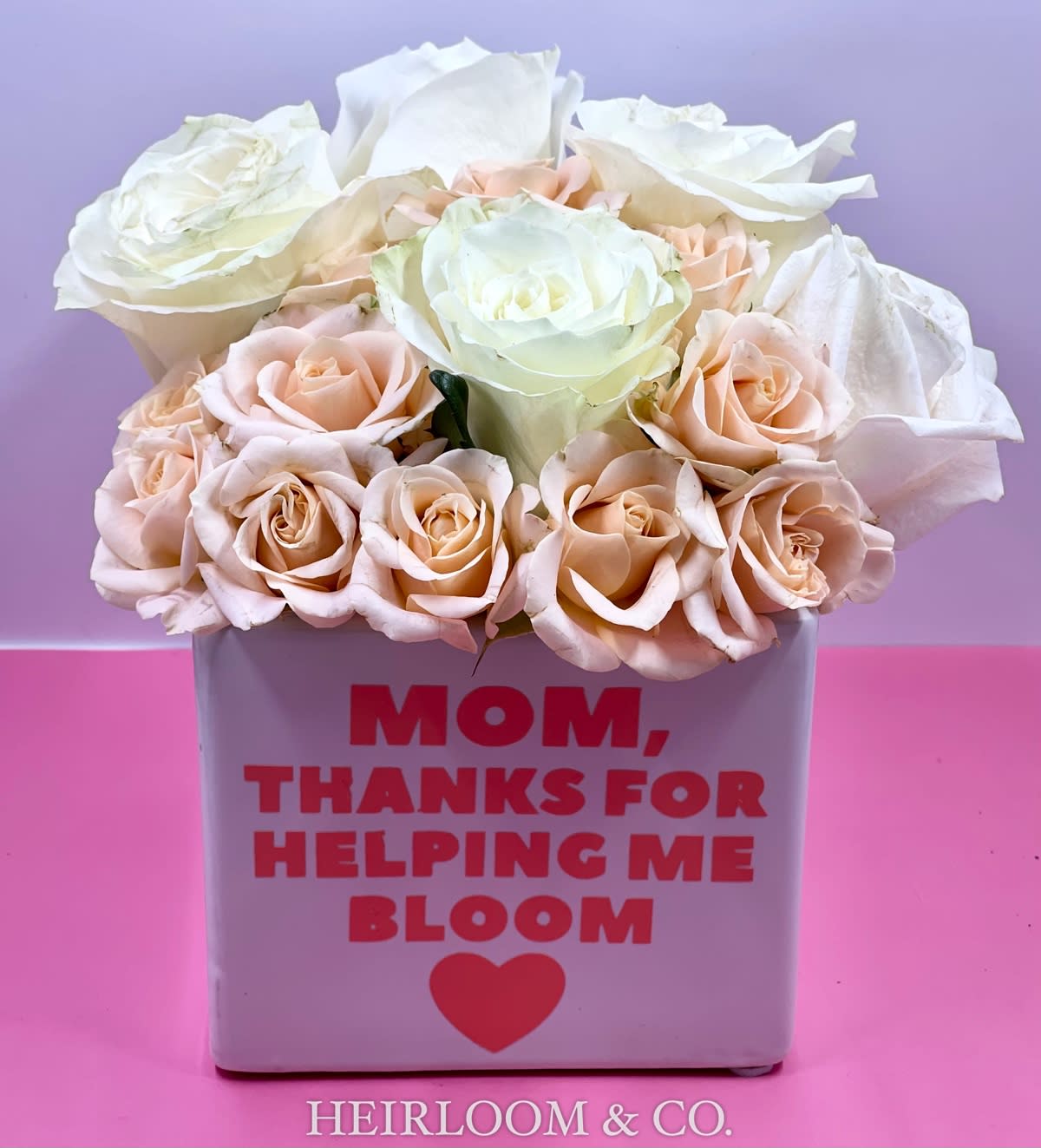 I love you Mom I love you Mom - An arrangement that will make any mother's heart melt! Presented in a white cube ceramic container, as pictured here, this adorable arrangement is filled with premium blush mini spray roses, and ultra premium white garden roses.