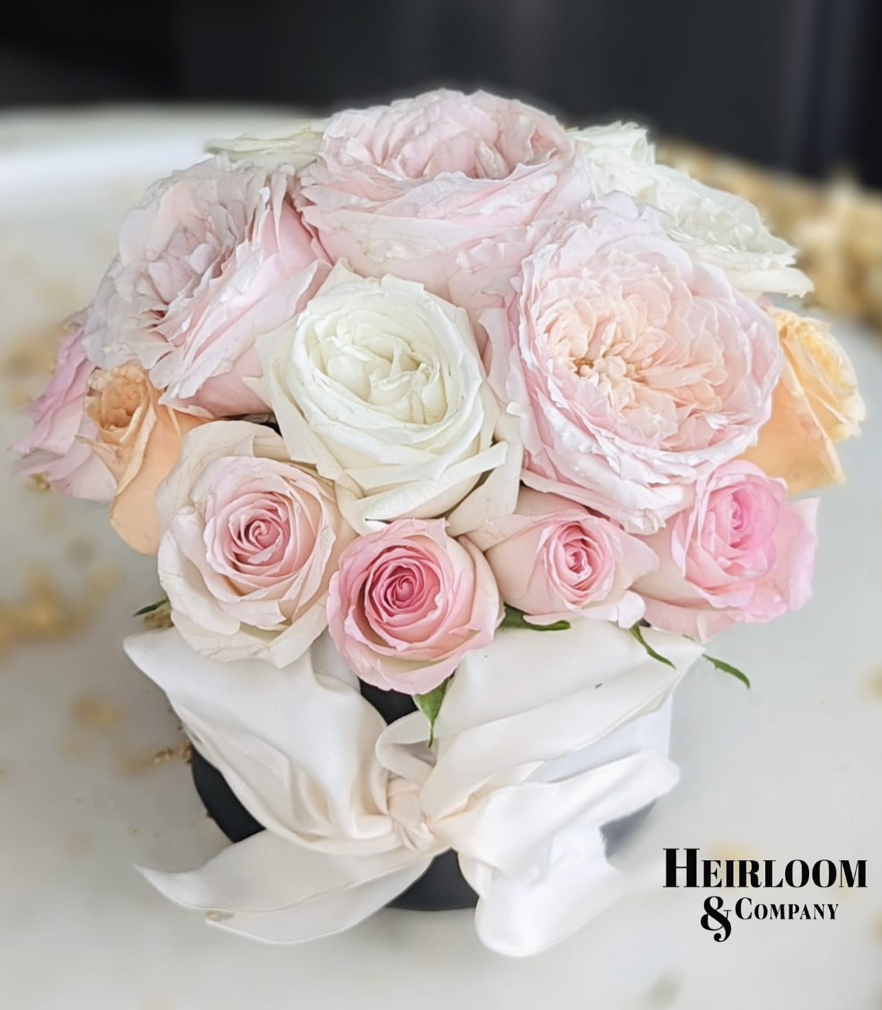 Fruitcake Fruitcake - This arrangement is sure to make anyone’s day a little bit brighter. Presented in a matte black hat box with a Selfies satin ivory bow, this arrangement is filled with the softest and most cheerful Premium hand selected garden roses.