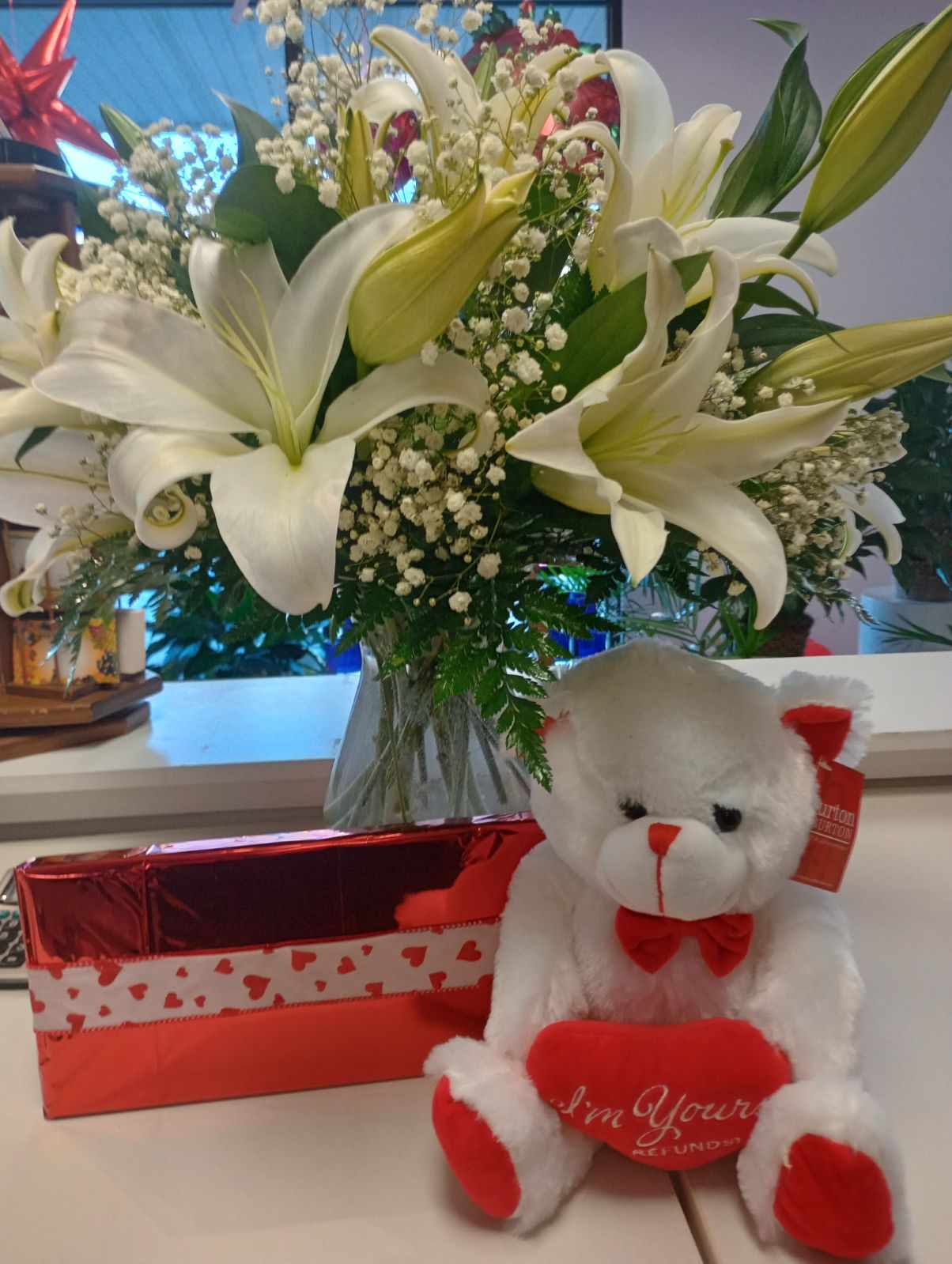 Lilly Bouquet Combination Gift - A beautiful clear vase full of lillies and babies breath paired with a 10in teddy bear and box of chocolates.
