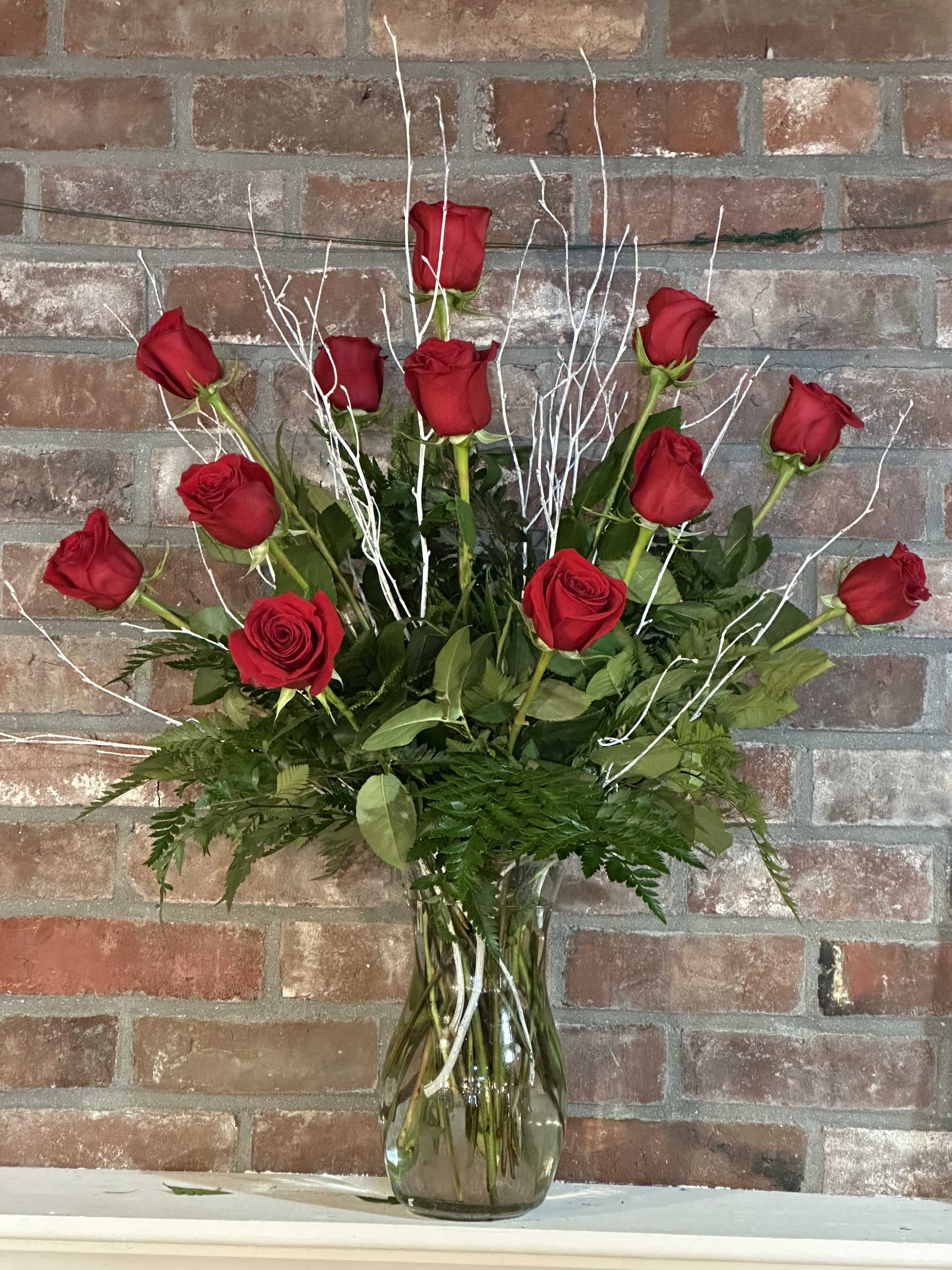 Twelve Red Roses - A charming bouquet of a dozen fresh and fragrant red roses, adorned with just a bit of greenery, is a classic Valentine’s Day gift. Delivered in a clear glass vase, this bouquet is also a romantic standard for any day of the year.