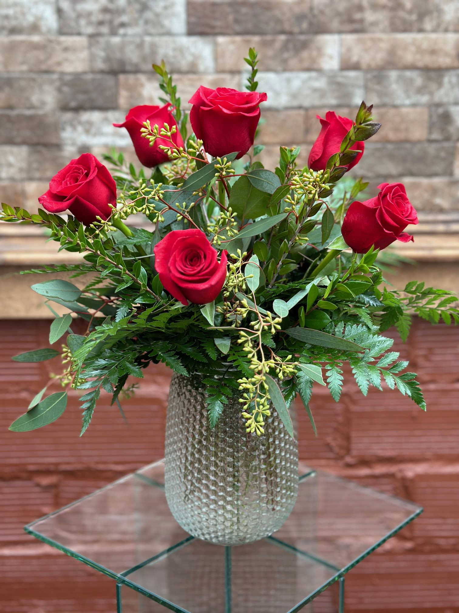 Half Dozen Red Roses  - Six beautiful roses in a cute clear, dimple vase with mixed greenery and a filler flower of the designers choice.   For a different color- please specify in the special instructions 