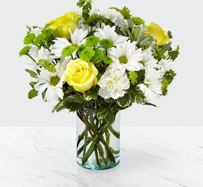 Happy Day Bouquet - It's amazing the effect flowers can have on its recipient. Through a collection of yellow roses and luminous bupleurum all set within a recycled cylindrical glass vase, our Happy Day bouquet is sure to bring a smile to the face of whoever it's given to. Add the combination of white daisy pompon and green button pompon, and you’ll be making their day brighter with each sunny petal.
