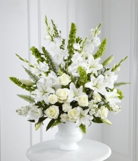 Pure Remembrance Pure Remembrance - Remembering the deceased with the purest of intentions. Send this all-white standing bouquet of roses, oriental Lily, bells of Ireland, carnations & gladiolus and your warmest sympathies will be felt by everyone. Approximately 26" H x 20" W