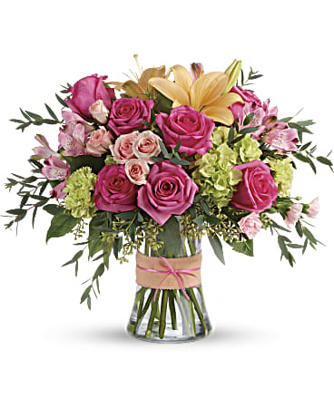 Blush Life Bouquet - Put a spring in their step with this beautifully blushing bouquet of hot pink roses, soft peach lilies and fresh green hydrangea. Arranged in a graceful vase tied with a charming bow, it's a chic treat for any occasion!  This sweet arrangement features green hydrangea, hot pink roses, pink spray roses, peach asiatic lilies, pink alstroemeria, green carnations, pink miniature carnations, seeded eucalyptus, parvifolia eucalyptus, and lemon leaf.  Delivered in a glass gathering vase.  Orientation: All-Around  SUBSTITUTION POLICY – Always deliver the freshest flowers! Please note the bouquet pictured reflects our original design.  If the exact flowers or container in this arrangement are not available, our local florists will create a beautiful bouquet with the freshest available flowers.