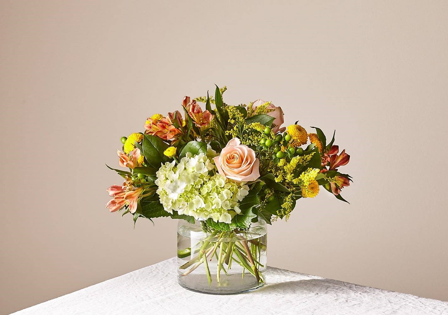 FTD Life's A Peach Bouquet - **MAIN PHOTO SHOWS DELUX OPTION**  This radiant bouquet is designed with a dreamy mix of peach, yellow, and light green blooms to create the perfect impression. Whether it's sent as a pick–me–up, a celebration, or just to make someone smile, everything is just peachy once this arrangement arrives.  Please Note: The bouquet pictured reflects our original design for this product. While we always try to follow the color palette, we may replace stems to deliver the freshest bouquet possible, and we may sometimes need to use a different vase.