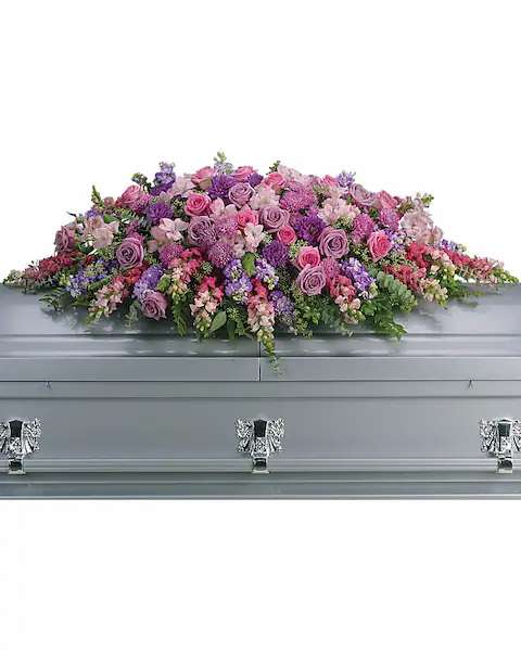 Tribute lavender casket spray Tribute lavender casket spray - Like a heartfelt embrace, this beautiful casket spray delivers comfort and love in an extraordinary way. A wonderful array of lavender and pink flowers with just the right amount of greenery is a lovely way to pay tribute to someone who will always be with you in heart, mind and spirit. Lovely lavender and pink roses, snapdragons, alstroemeria, chrysanthemums, fern, eucalyptus and more create this tribute that is overflowing with grace and love.