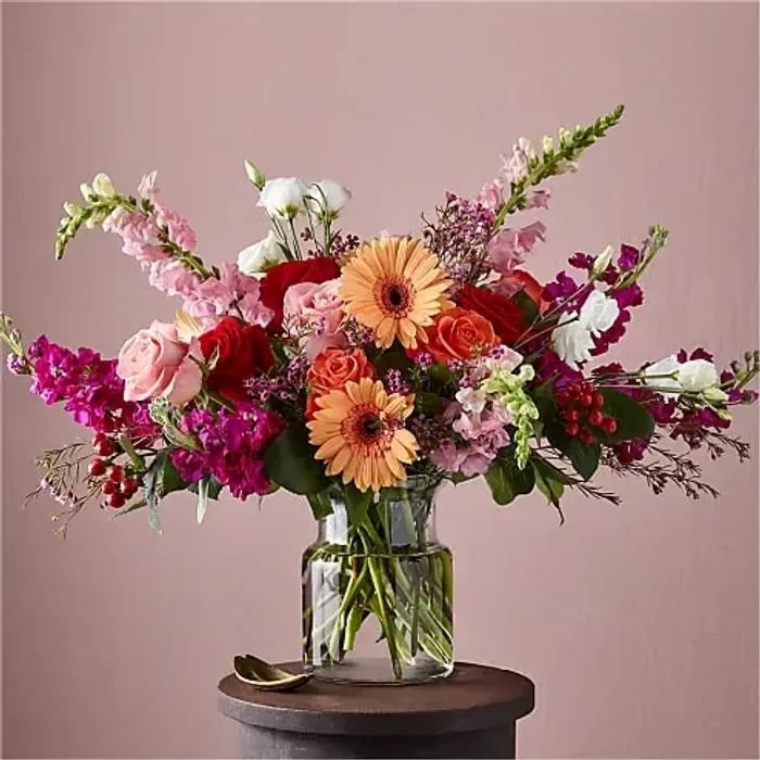 Grand Gesture Bouquet - Show them how you really feel with our Grand Gesture Bouquet. The peach gerbera daisies and pink roses anchor the arrangement, letting the hot pink waxflower, white lisianthus and pink snapdragons extend outward. This stunning bouquet will have your inner hopeless romantic ready for that storybook ending.