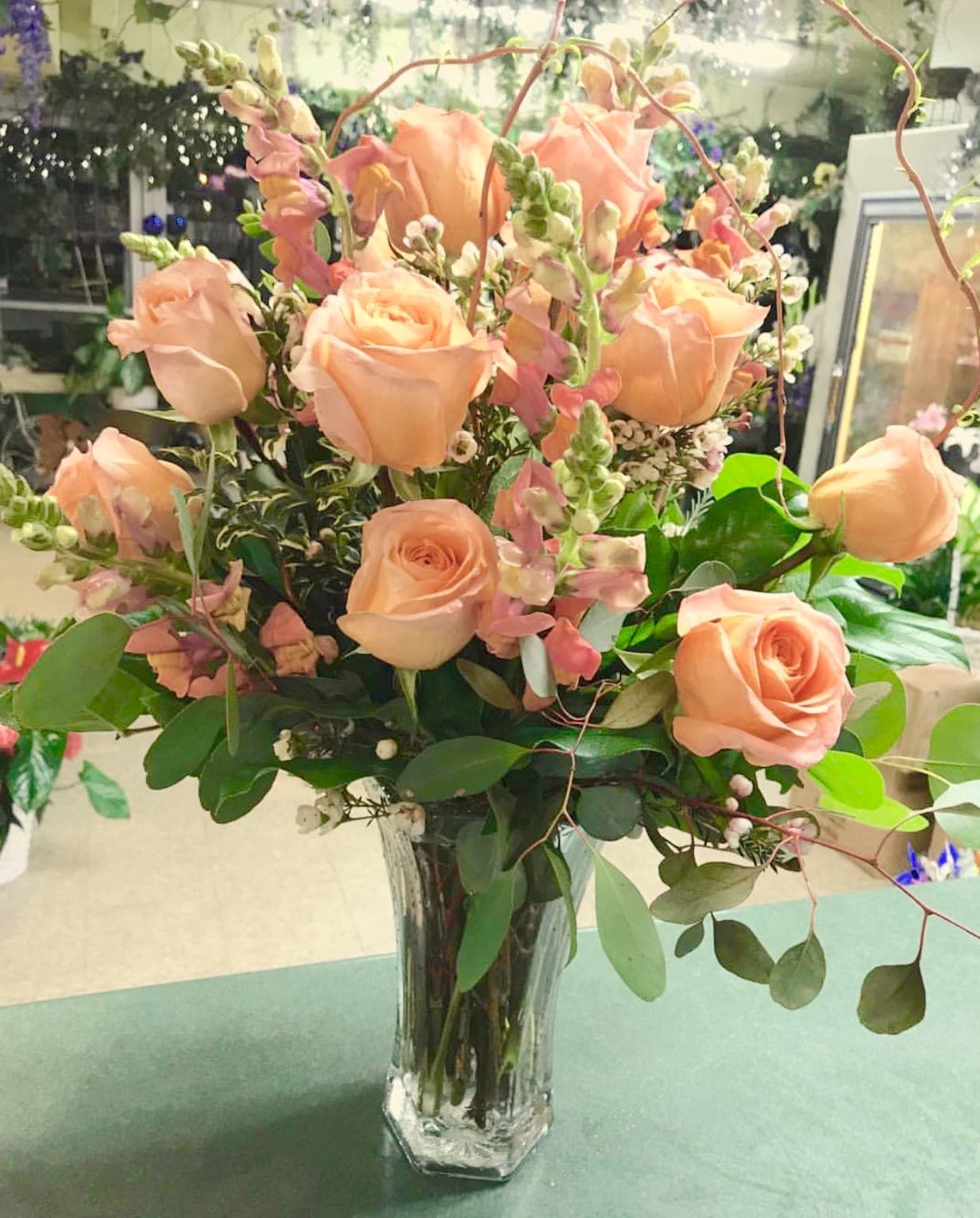Oh Snap Oh Snap - Premium coral tone roses and snapdragons in a clear glass vase.