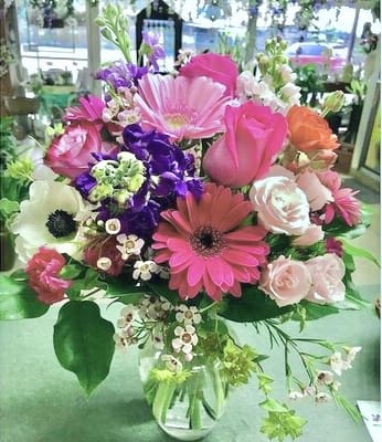 XoXo XoXo - A beauty fresh arrangement of roses, gerbera daisies, stock, mini carnations and complementary flowers in a clear glass ginger vase.